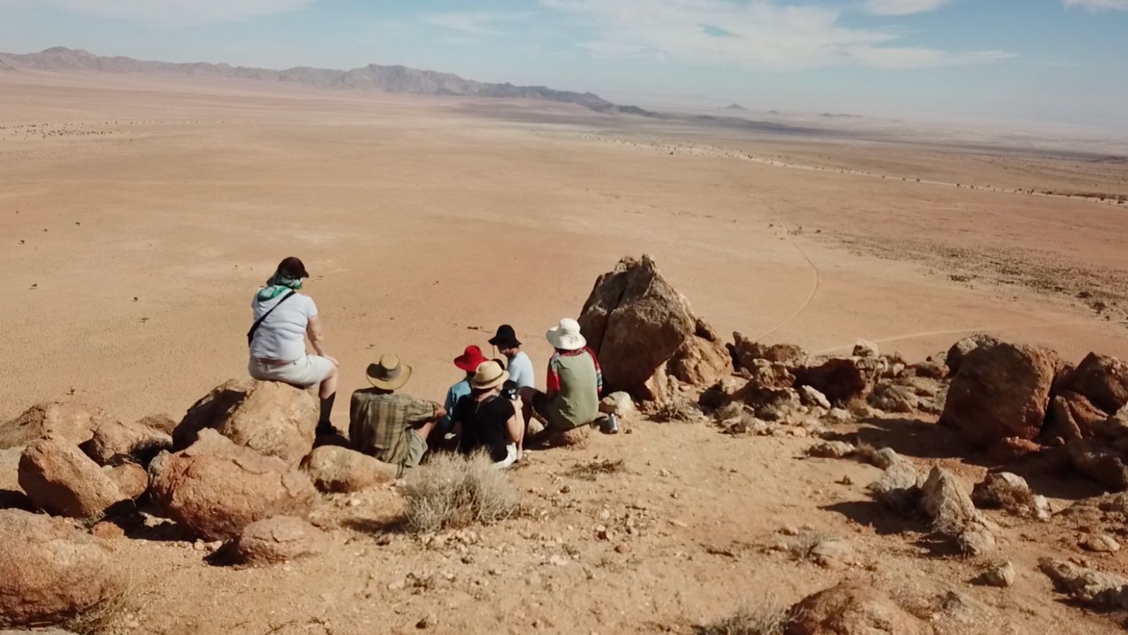 Team on desert landscape overlooking geoglyph site