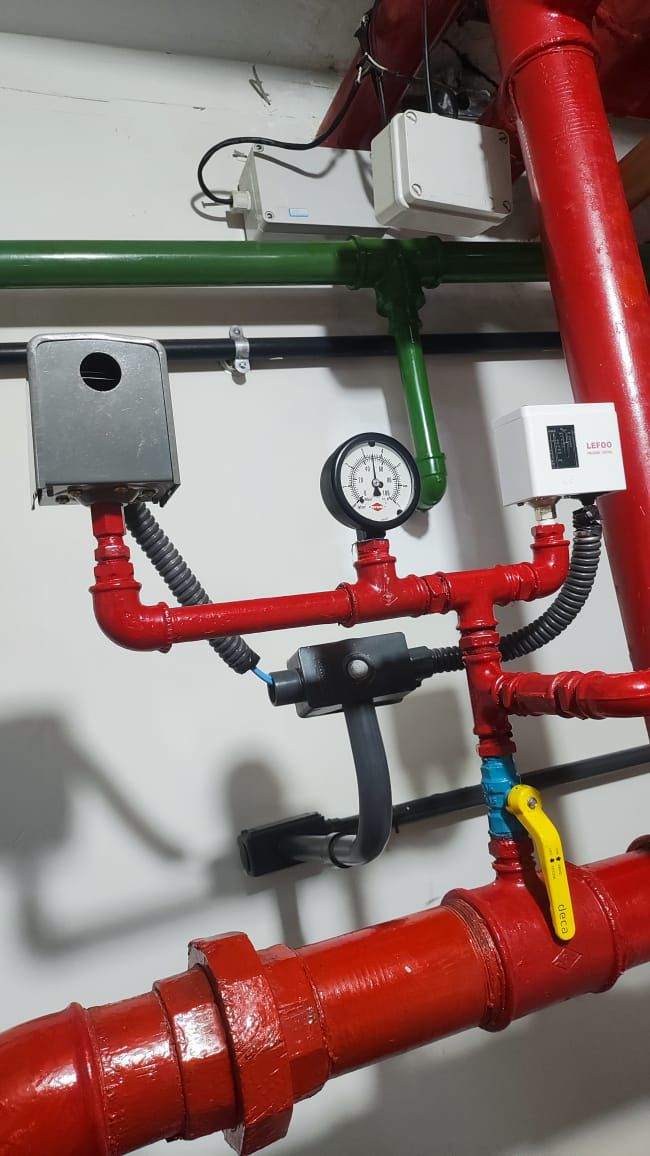 Casa de bombas com tubulação vermelha e motores elétricos