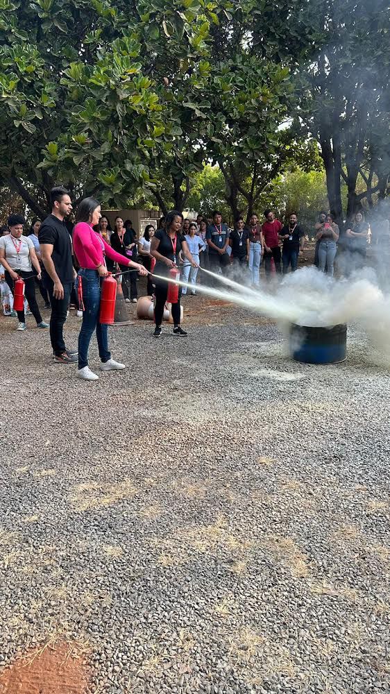 Simulacro de evacuação com bombeiro carregando mangueiras