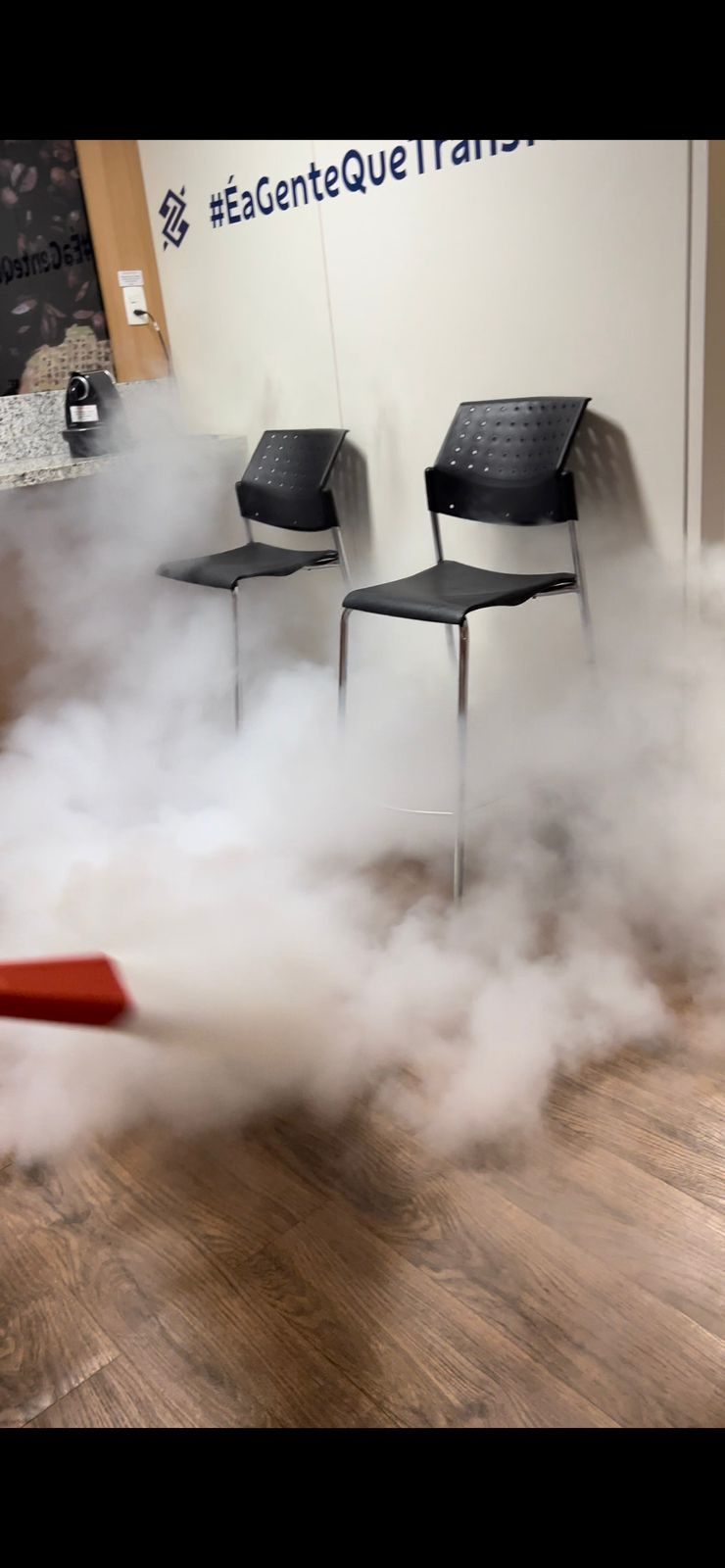 Extintor CO2 sendo acionado em ambiente fechado durante treinamento