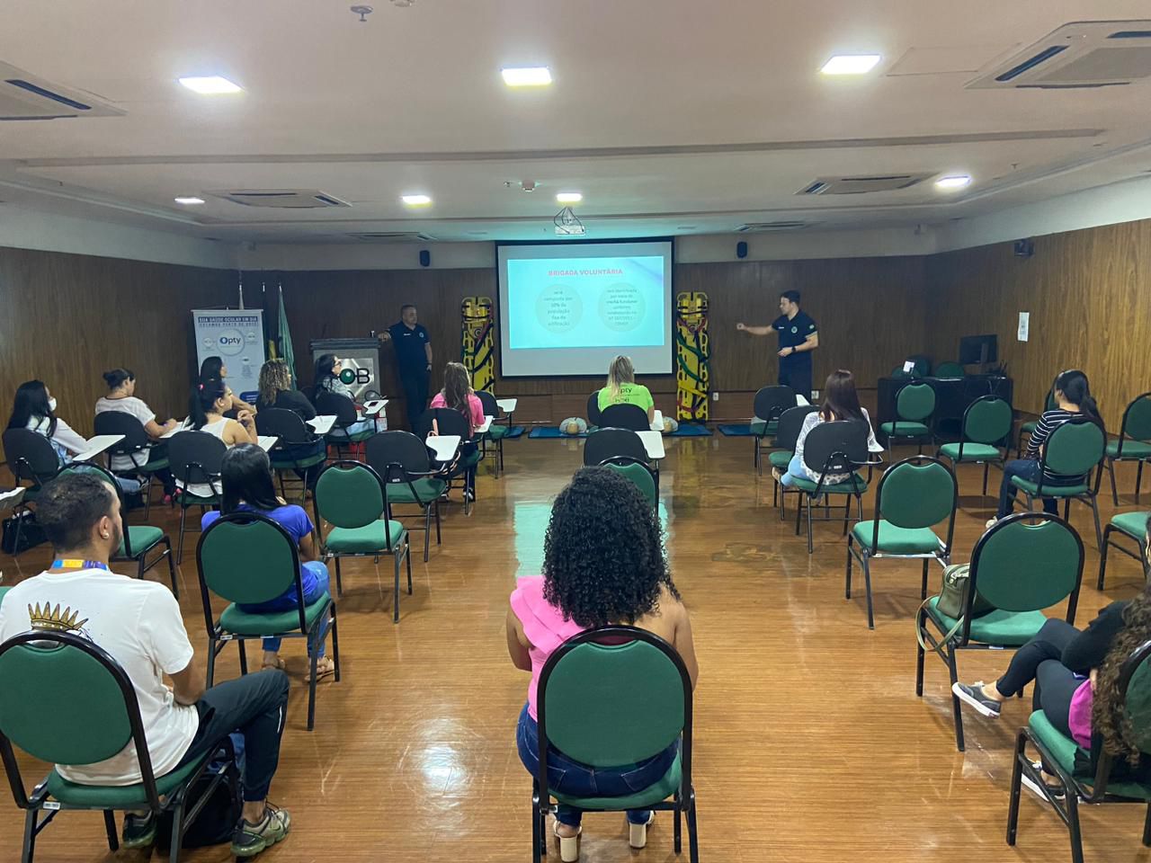 Formatura de brigada com extintores em frente a edifício corporativo