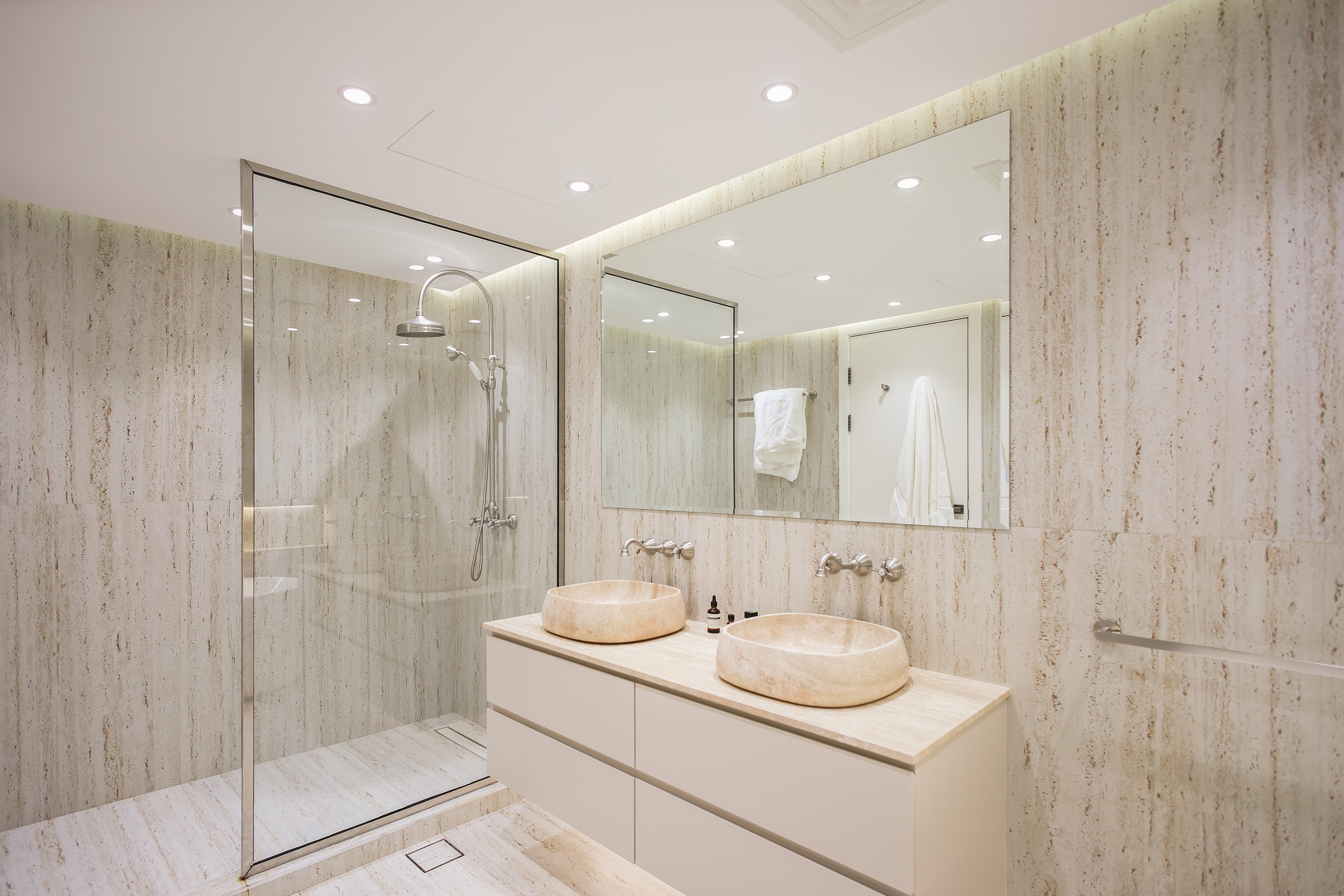 Spa bathroom with dual stone vessel sinks and glass shower