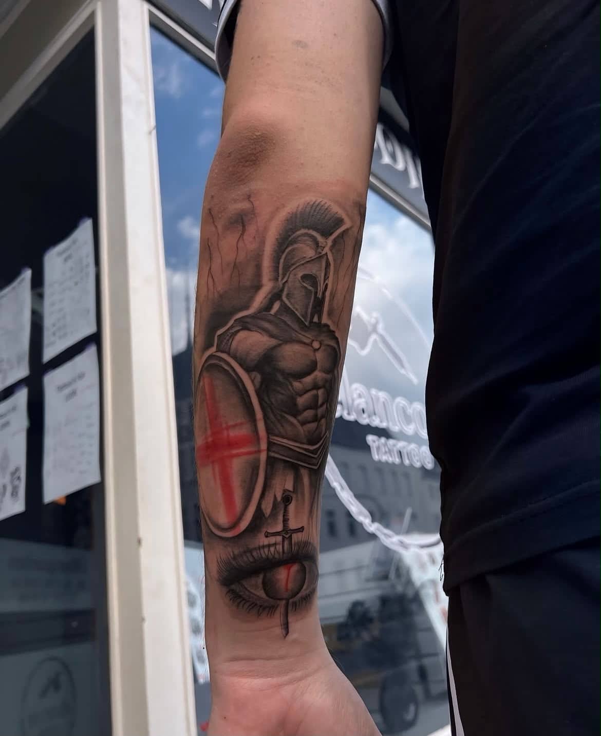 Black and Grey Spartaner mit rotem Kreuzschild und Auge am Unterarm