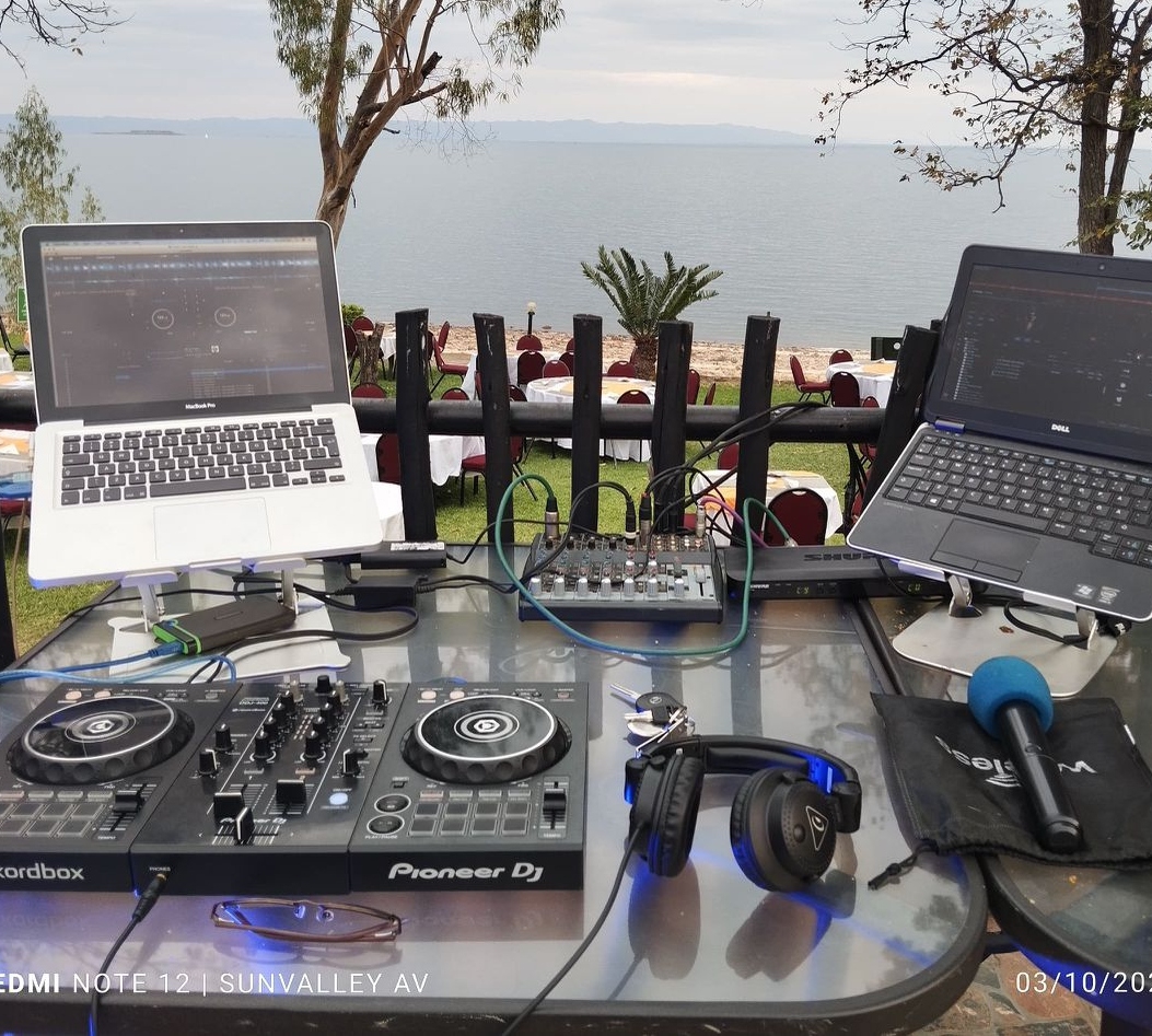 DJ and production setup with equipment at lakeside event
