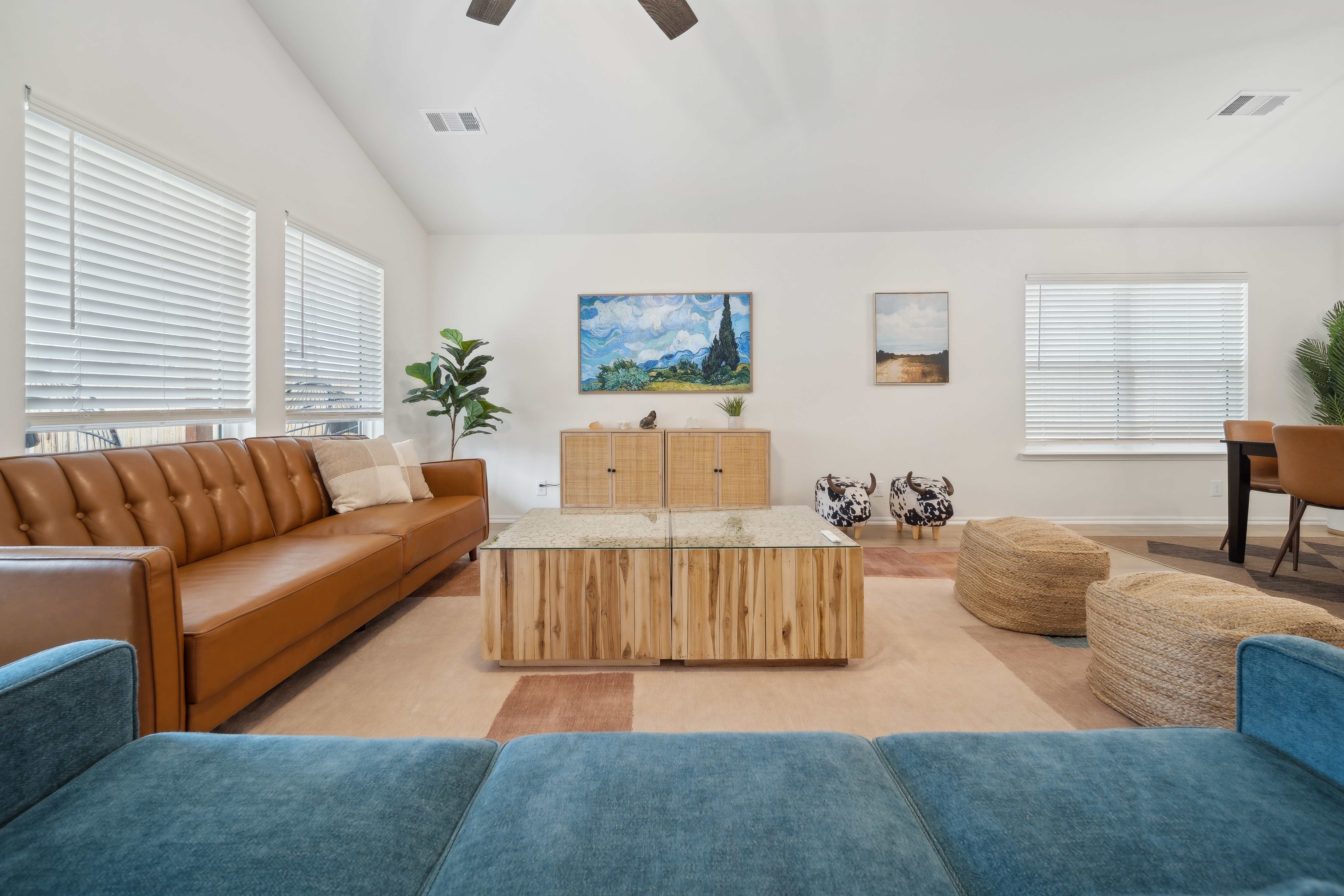 Living room with leather sofa, teal chairs, and Van Gogh art