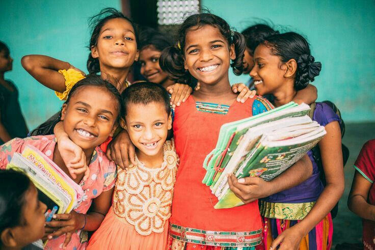 Children smiling together with schoolbooks