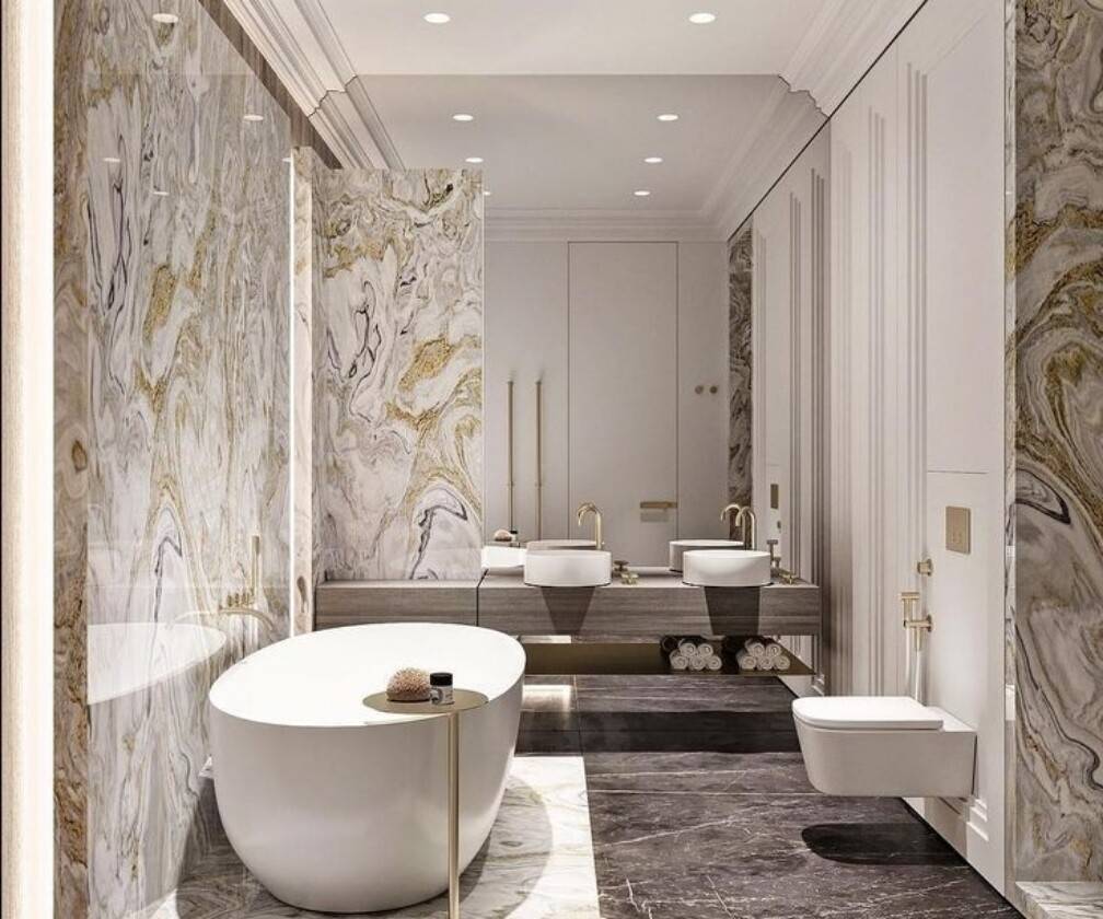 Classic European luxury bathroom with dramatic swirled marble slab walls, freestanding tub, dual vessel sinks, brass fittings, and full-length mirror