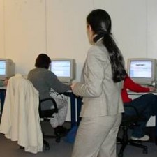 Betreuerin beaufsichtigt Teilnehmerinnen an PC-Plätzen