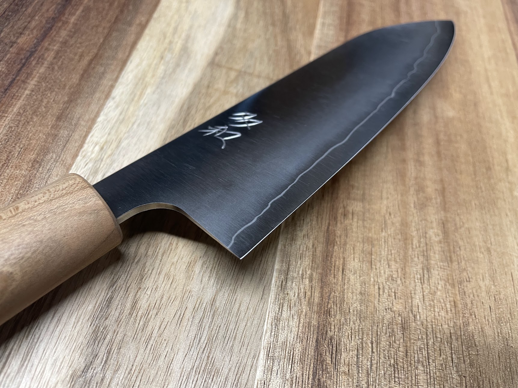 Japanese Deba knife with natural wood handle on cutting board