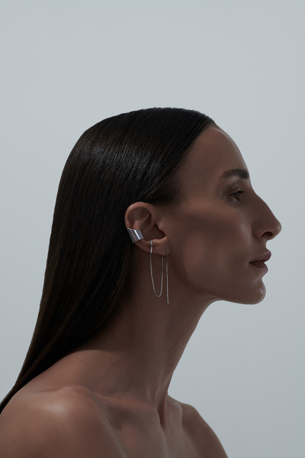 Portrait profile — silver ear cuff, dark hair