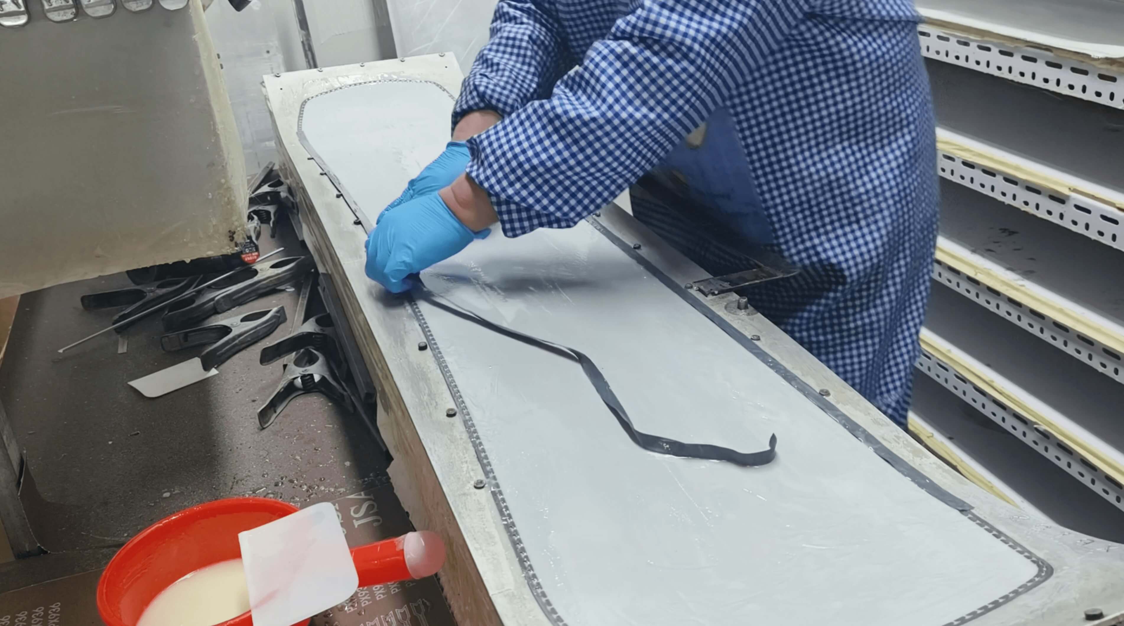 Rubber sidewall strip being carefully placed along the mold edge