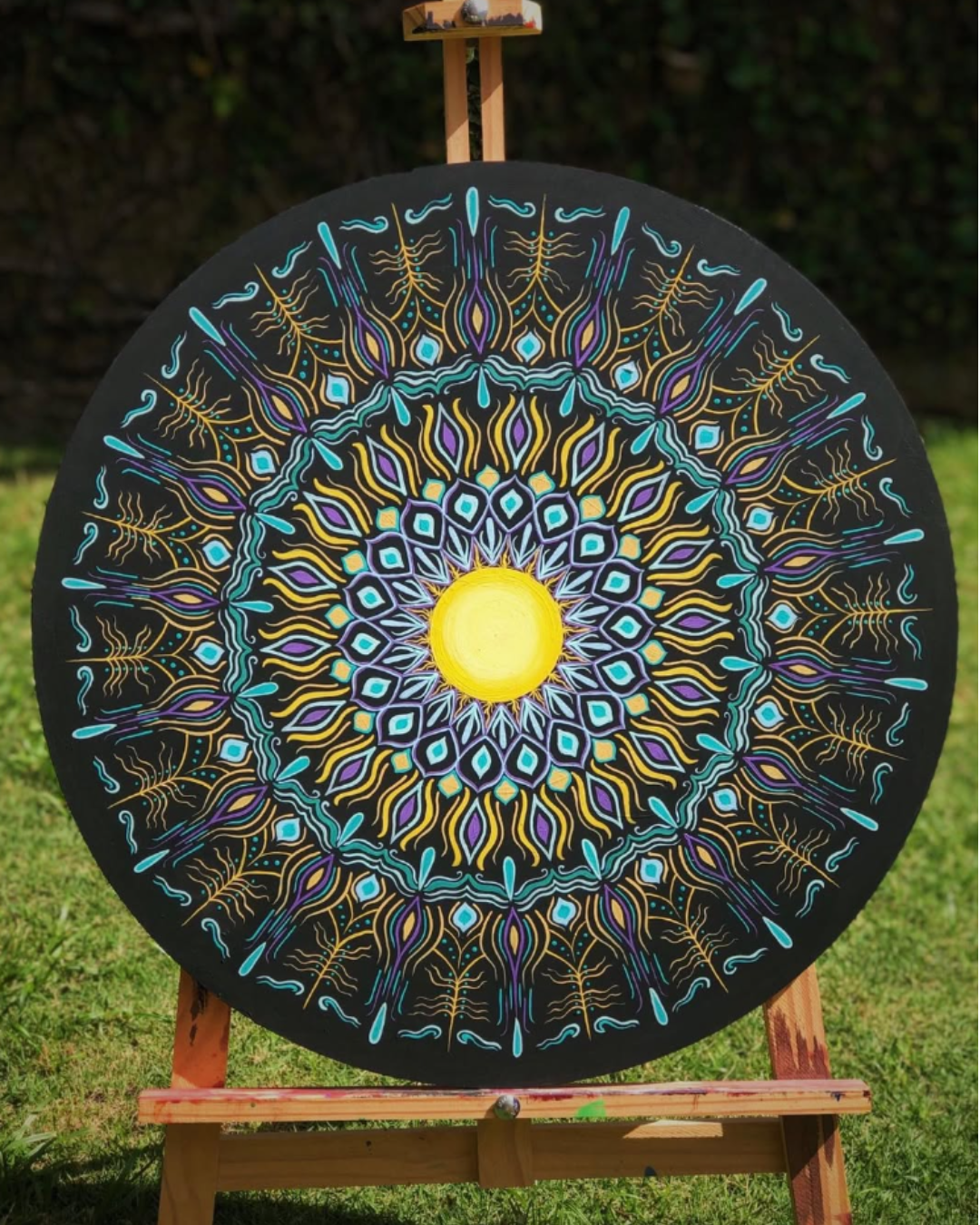 Mandala circular preta com padrão turquesa e amarelo