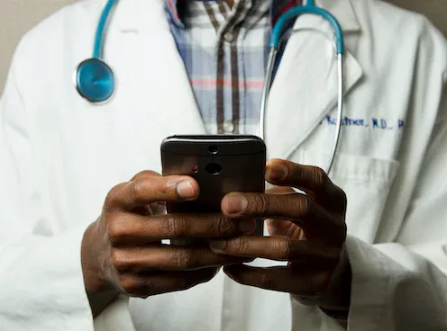 Doctor with smartphone providing telemedicine services