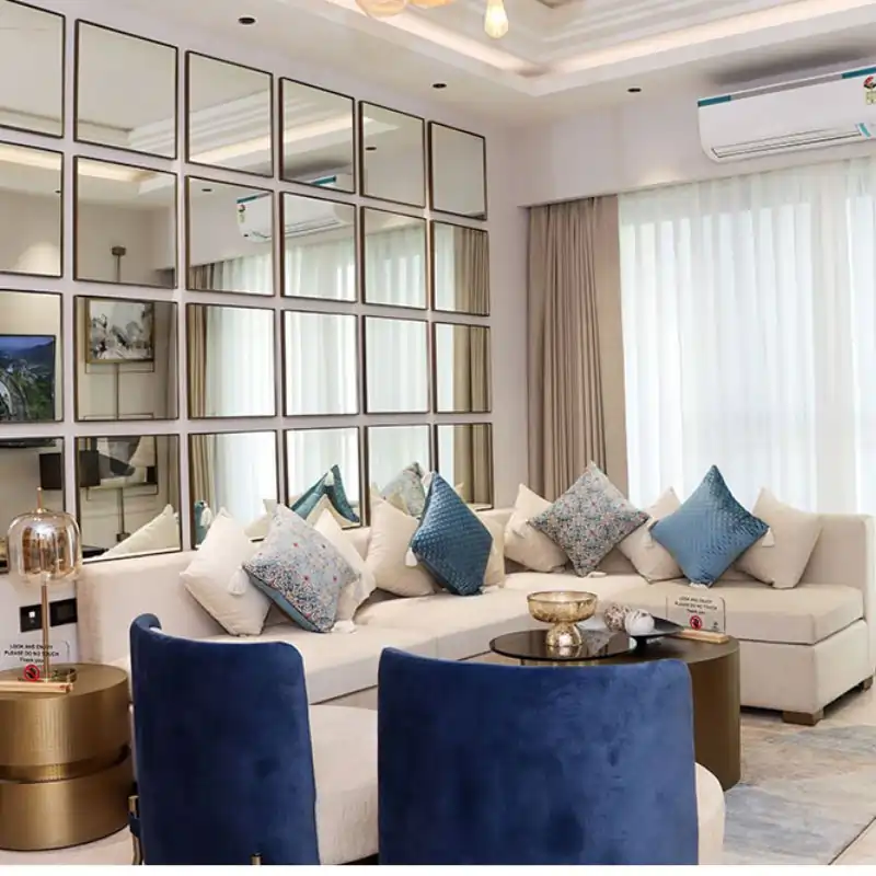 Wave Eden luxury living room with cream seating, blue pillows, and large mirror wall