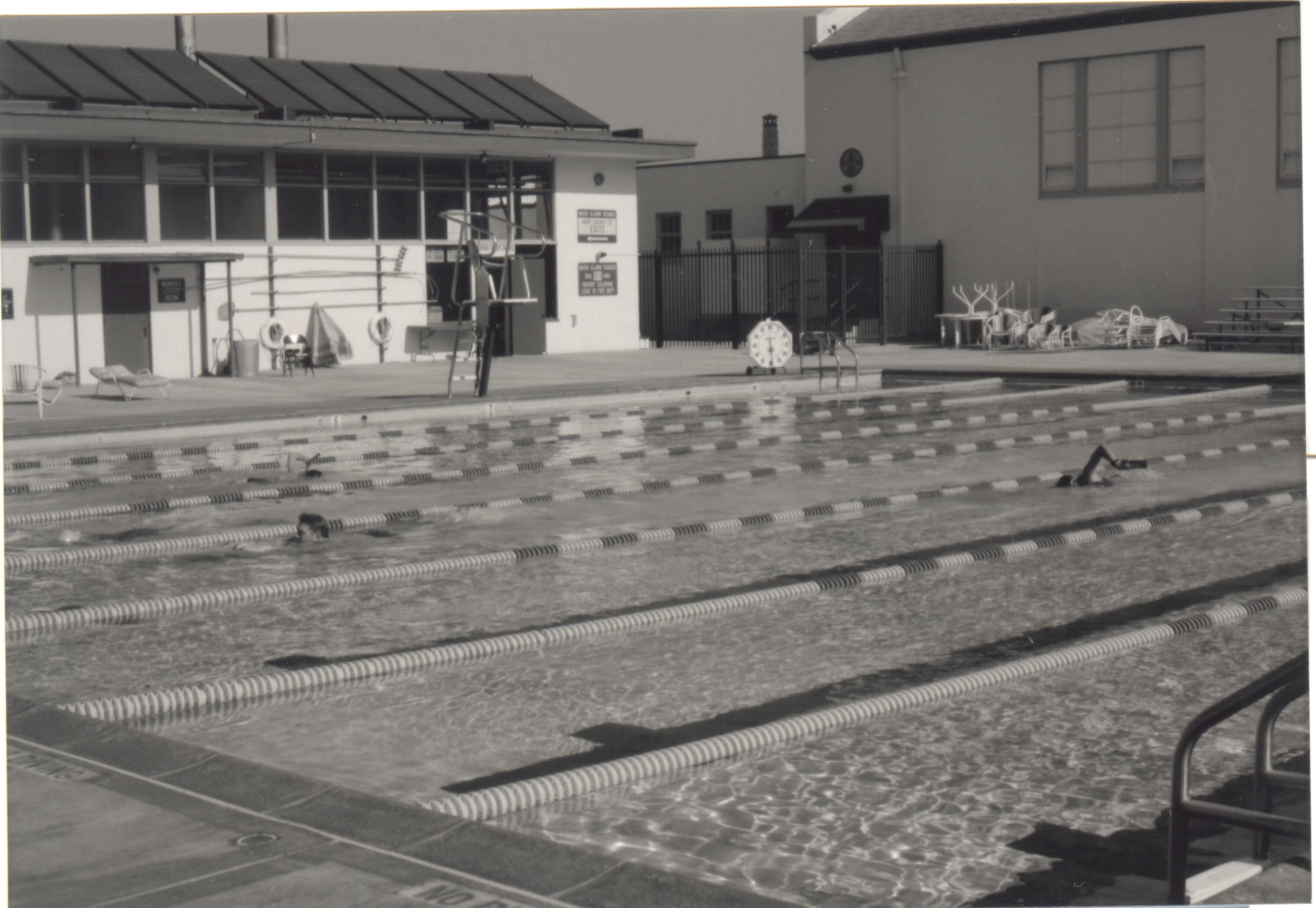 Campbell pool with swimmers, bleachers, and the original pool building.