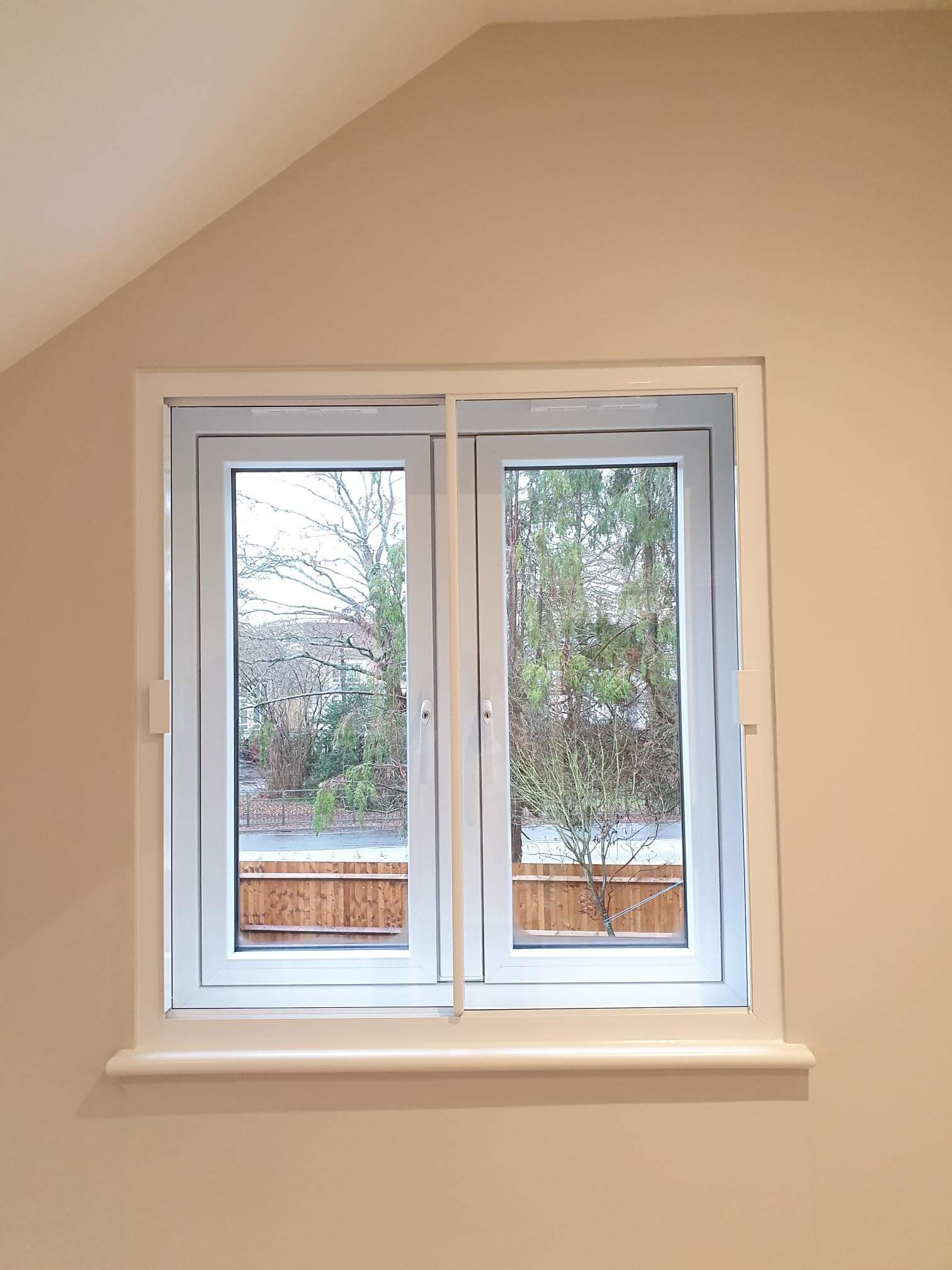Double casement windows with secondary glazing in London Barnet loft conversion with winter garden views