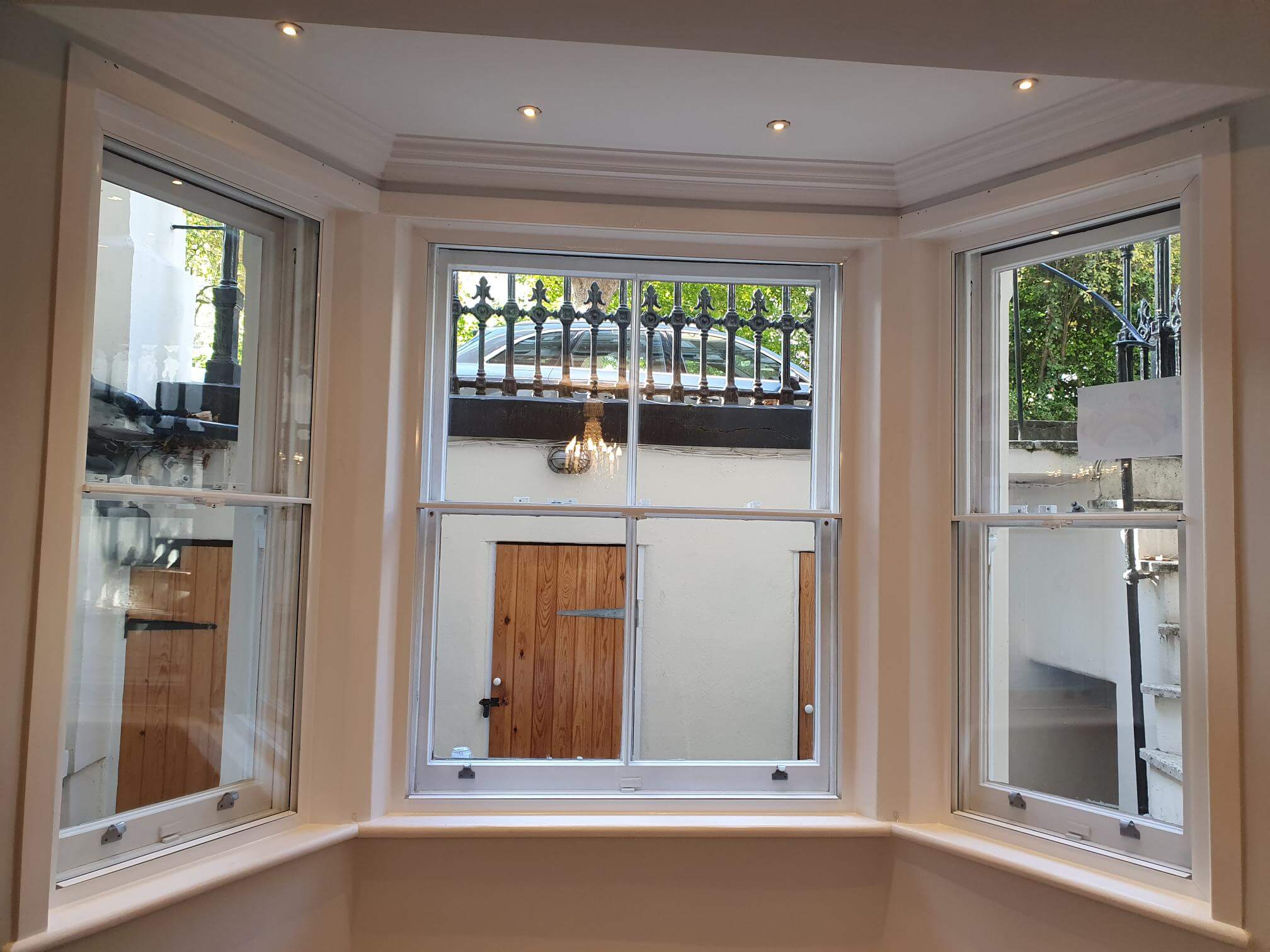 Victorian three-panel bay window with secondary glazing in London Notting Hill Gate basement flat with ornate railings