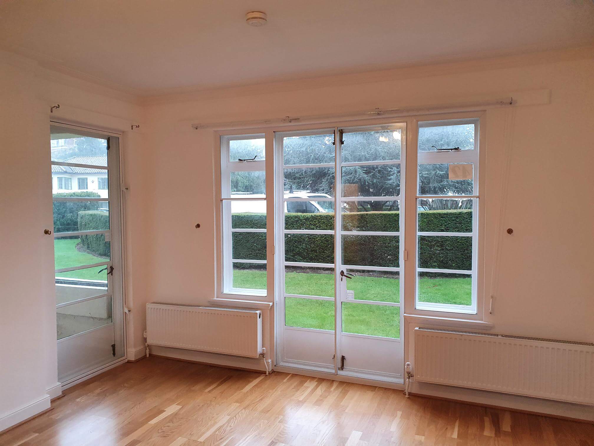 French doors and side windows with secondary glazing in London Wimbledon Village garden room overlooking manicured lawn