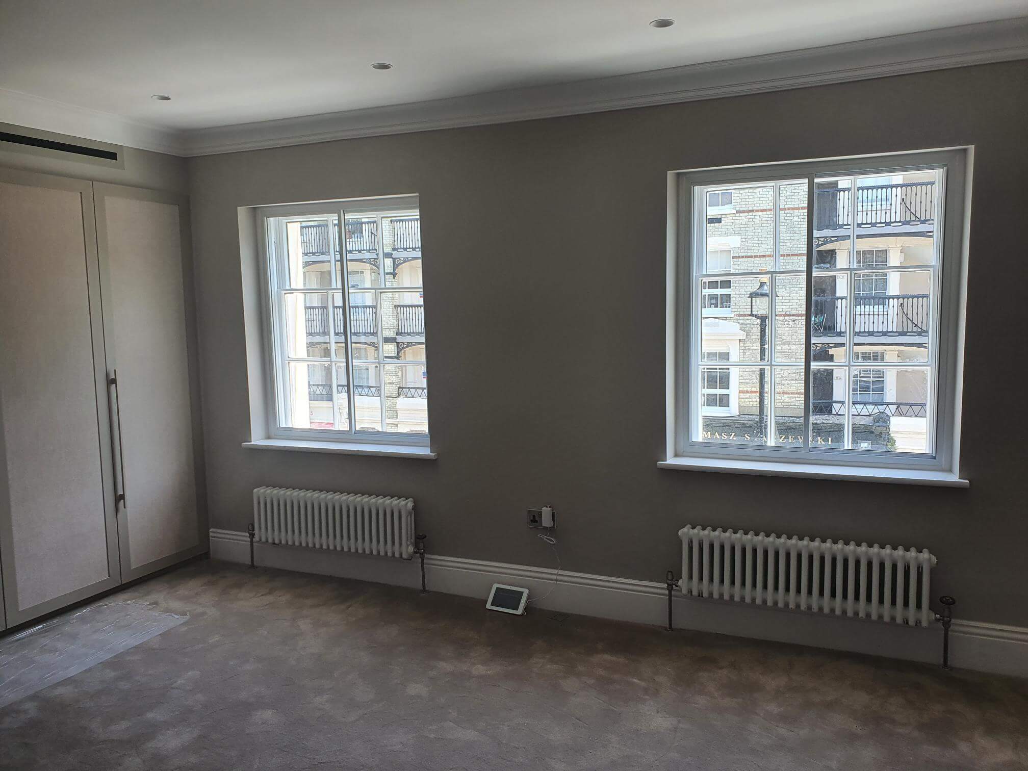 Two sash windows with secondary glazing in elegant grey London Belgravia master bedroom with period radiators