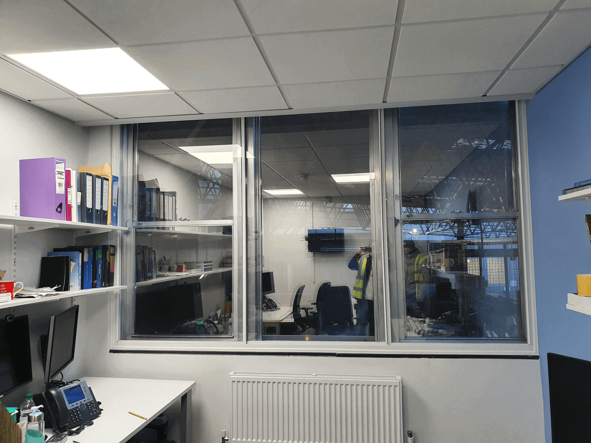 Triple-panel secondary glazing in London Stratford industrial warehouse office overlooking factory floor