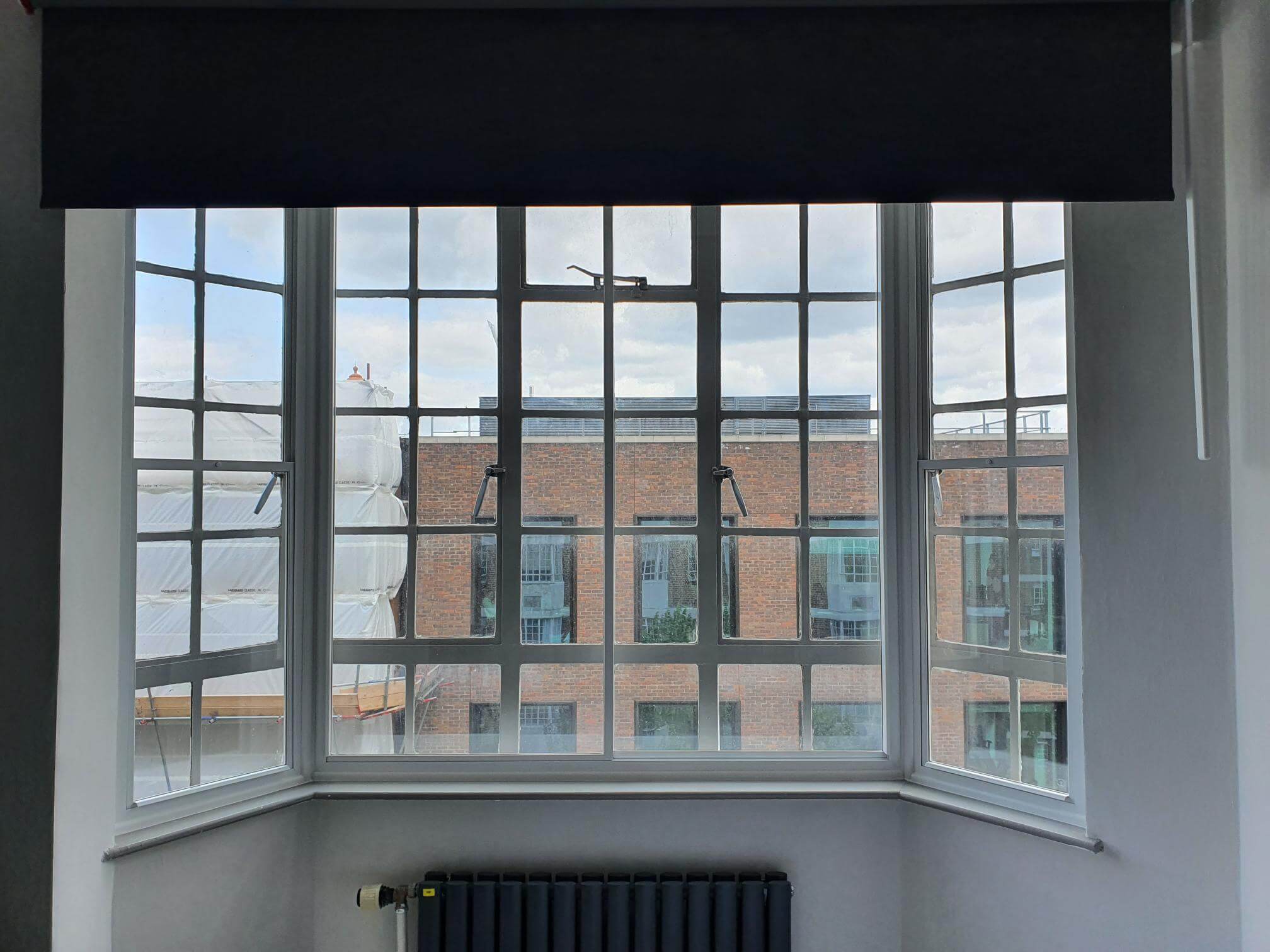 Large Crittall-style bay window with secondary glazing in London Clerkenwell warehouse conversion overlooking industrial buildings