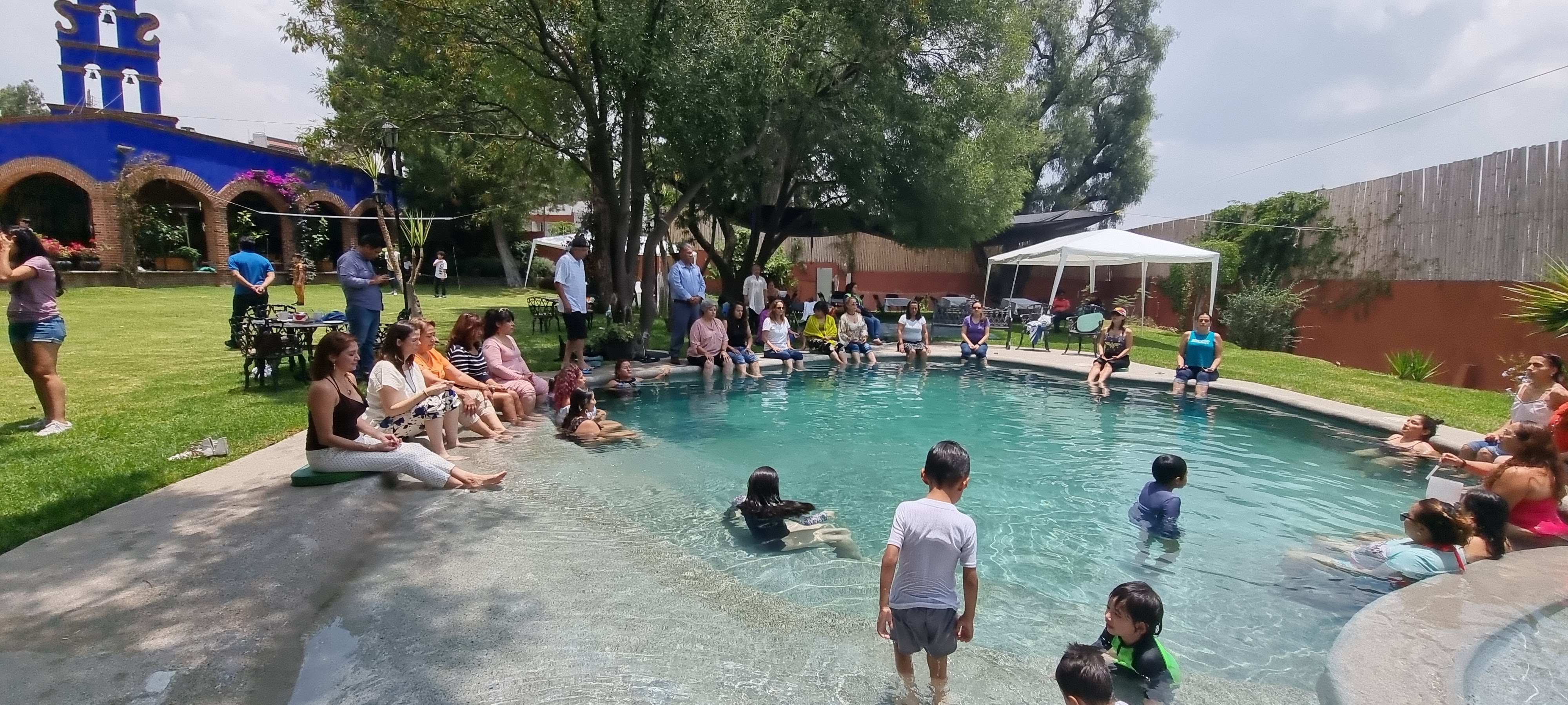 Familias disfrutando la alberca con torre azul