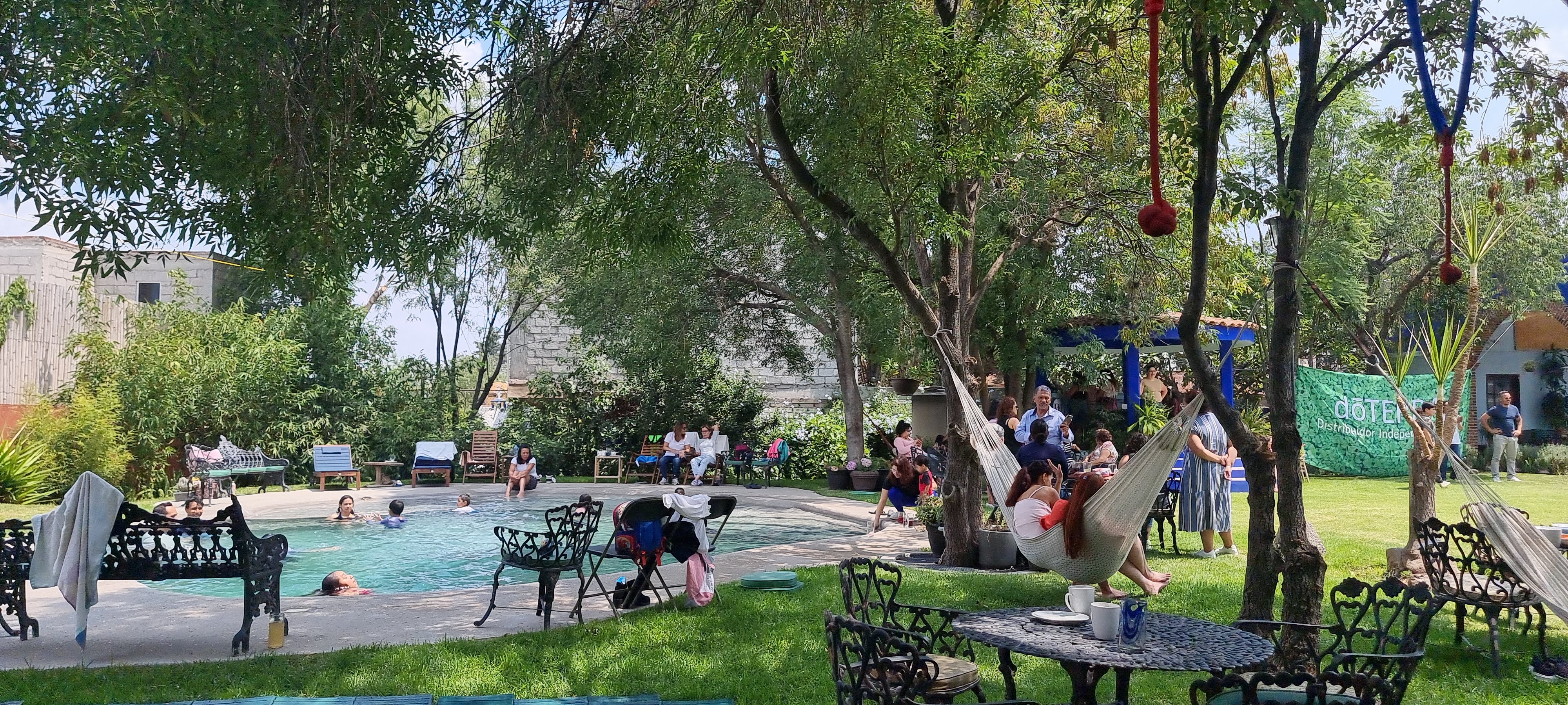 Área de alberca con hamacas y mesas
