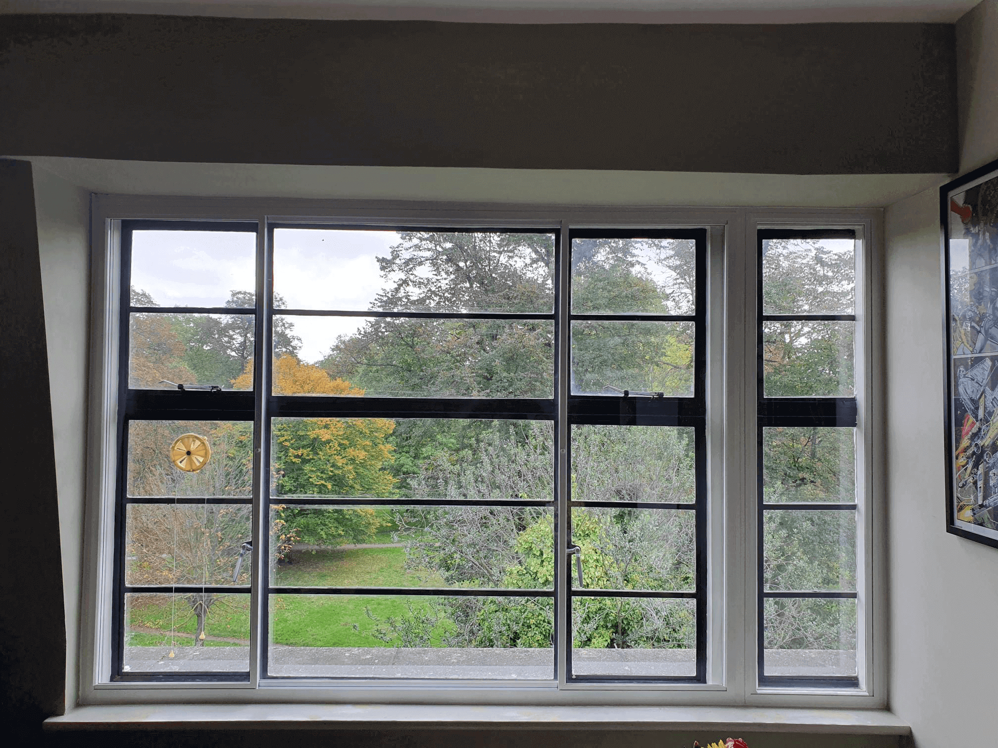 Black Crittall-style secondary glazing with autumn garden views in London Highgate property