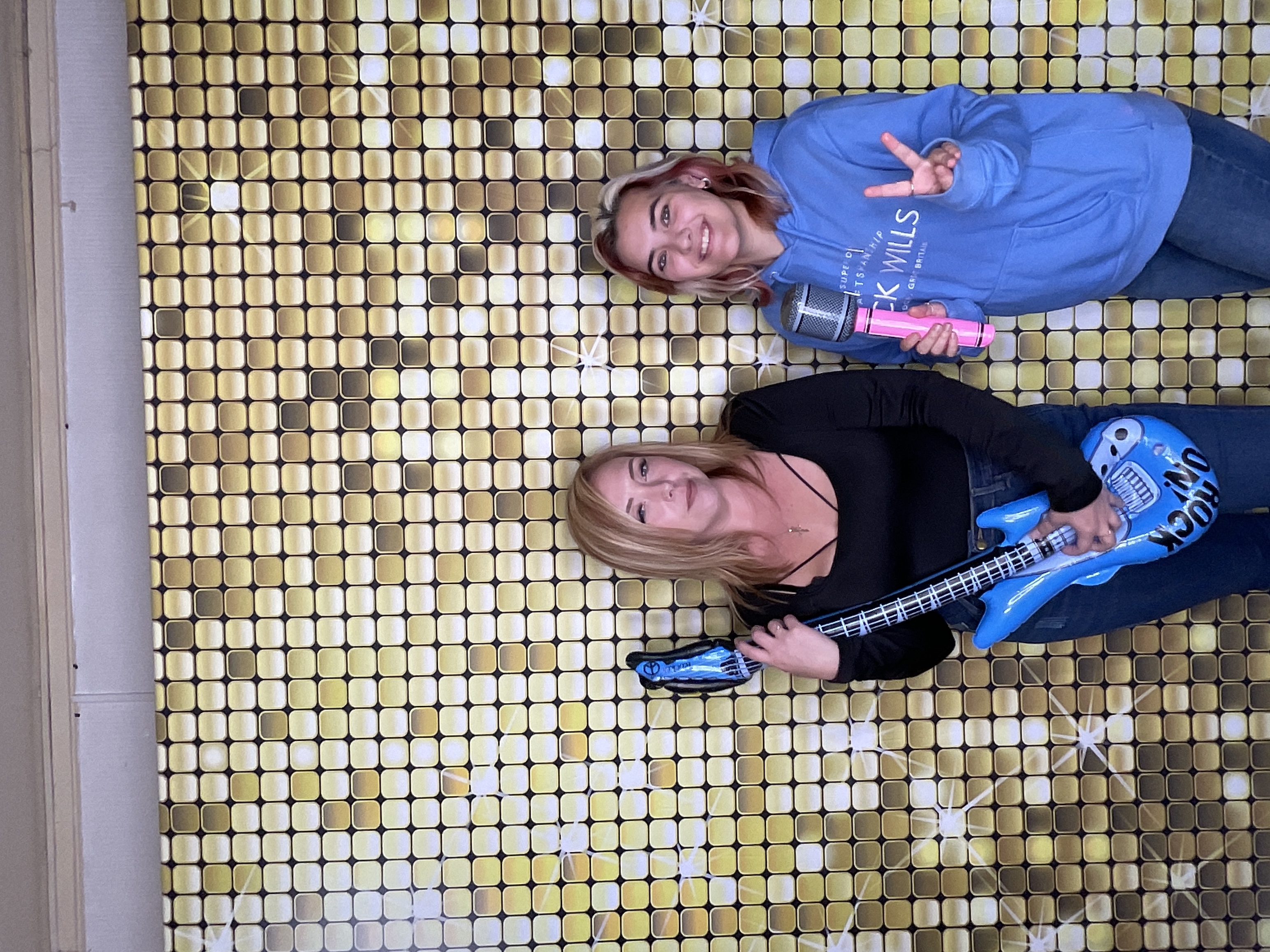 Two women at gold sequin backdrop Hull