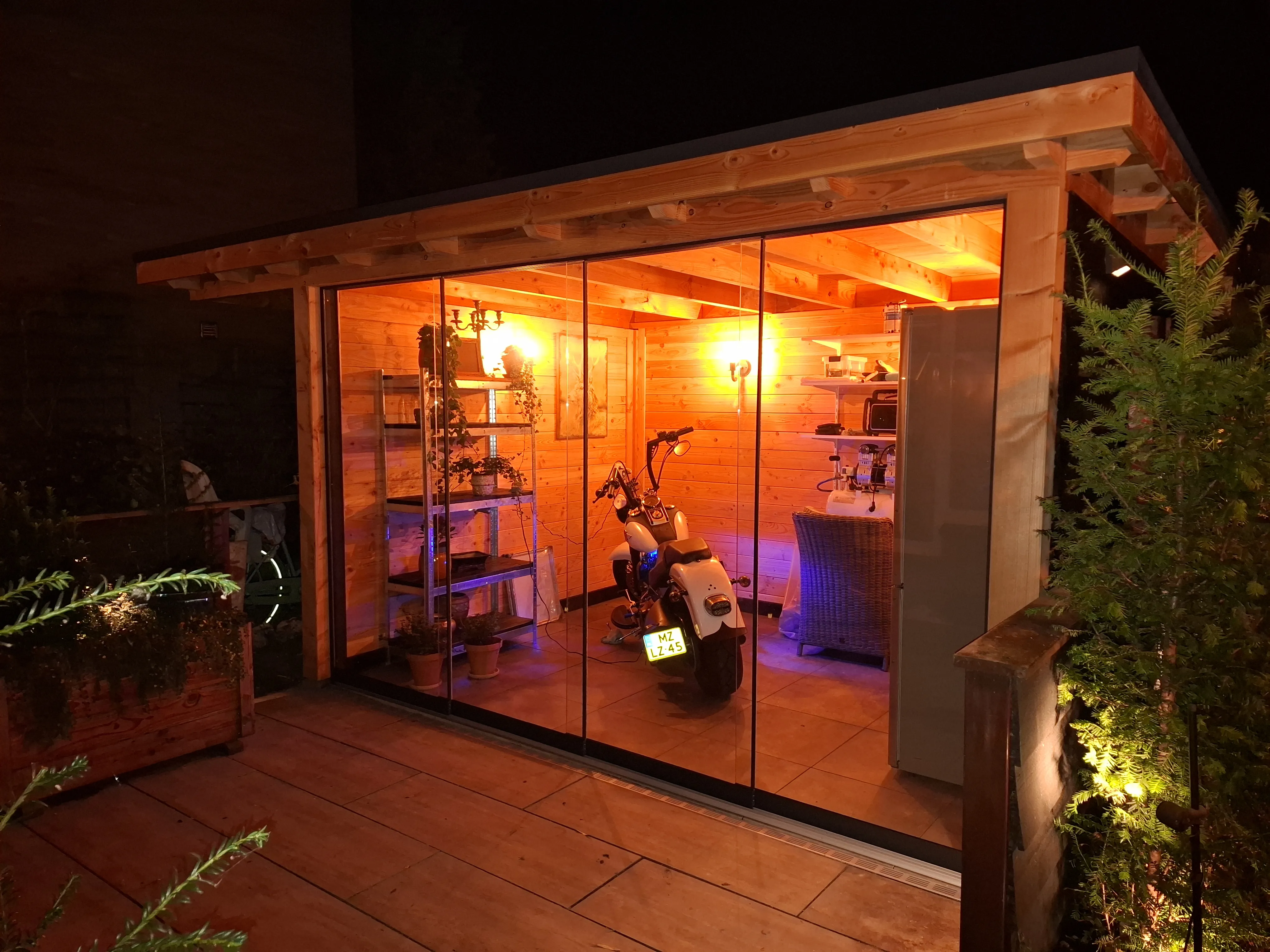 Veranda bij avond, sfeervol verlicht - Tuinaanleg Zoetermeer