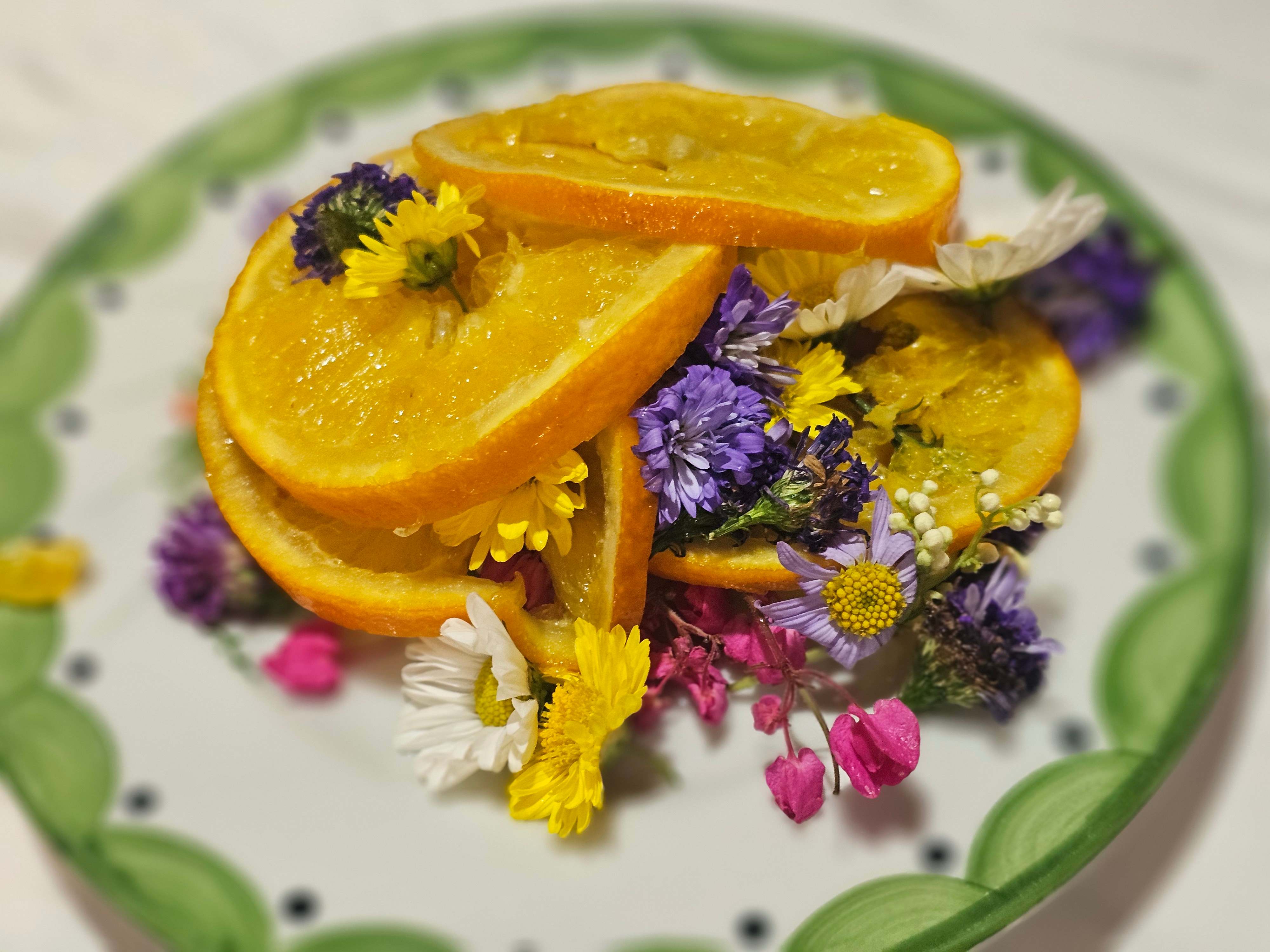 Fresh orange slices with edible flowers dessert