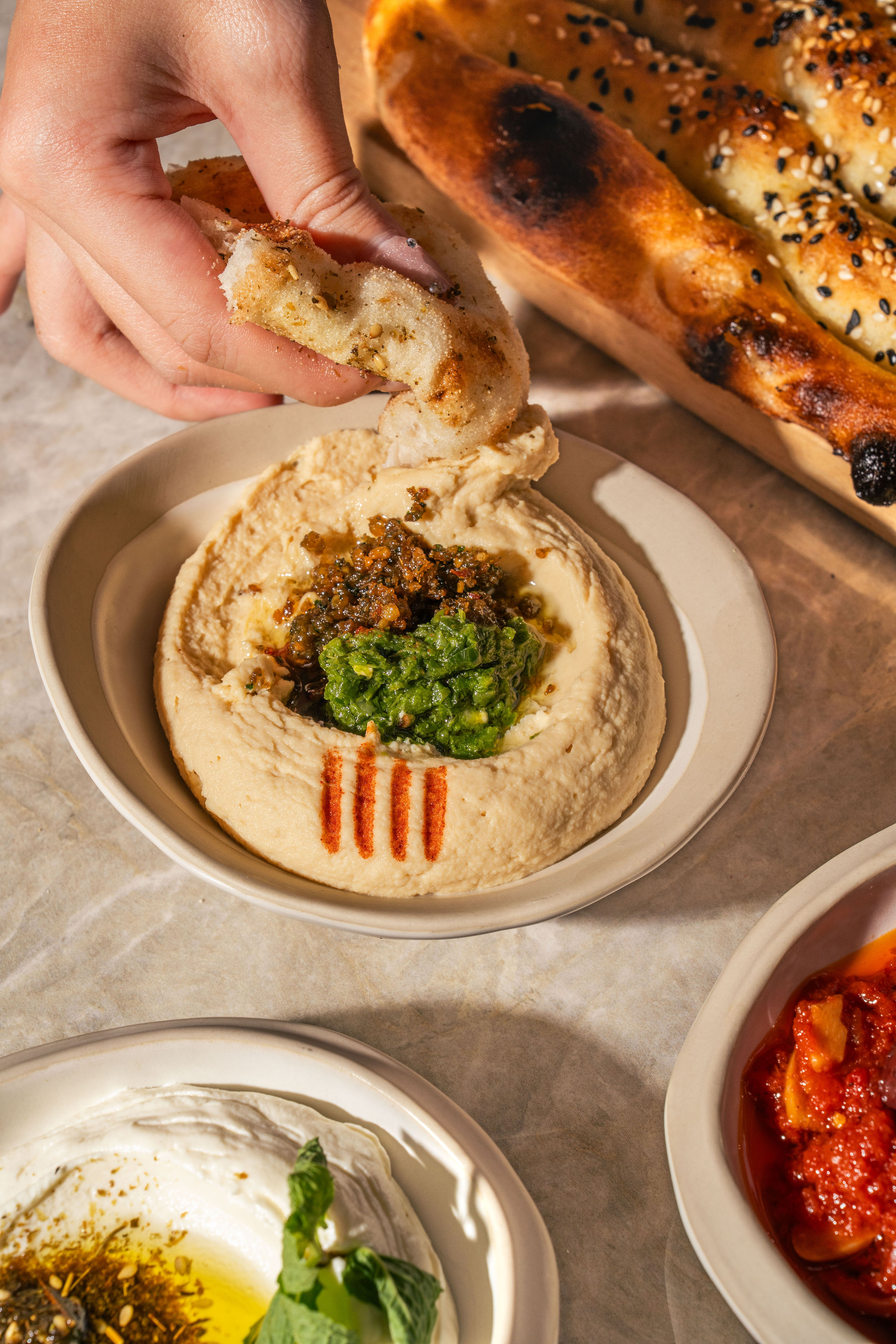 Freshly baked bread dipped into housemade hummus with mezze