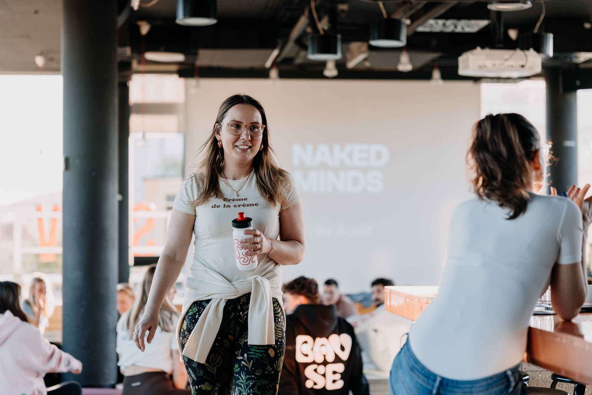 Participant smiling in front of a Naked Minds projection