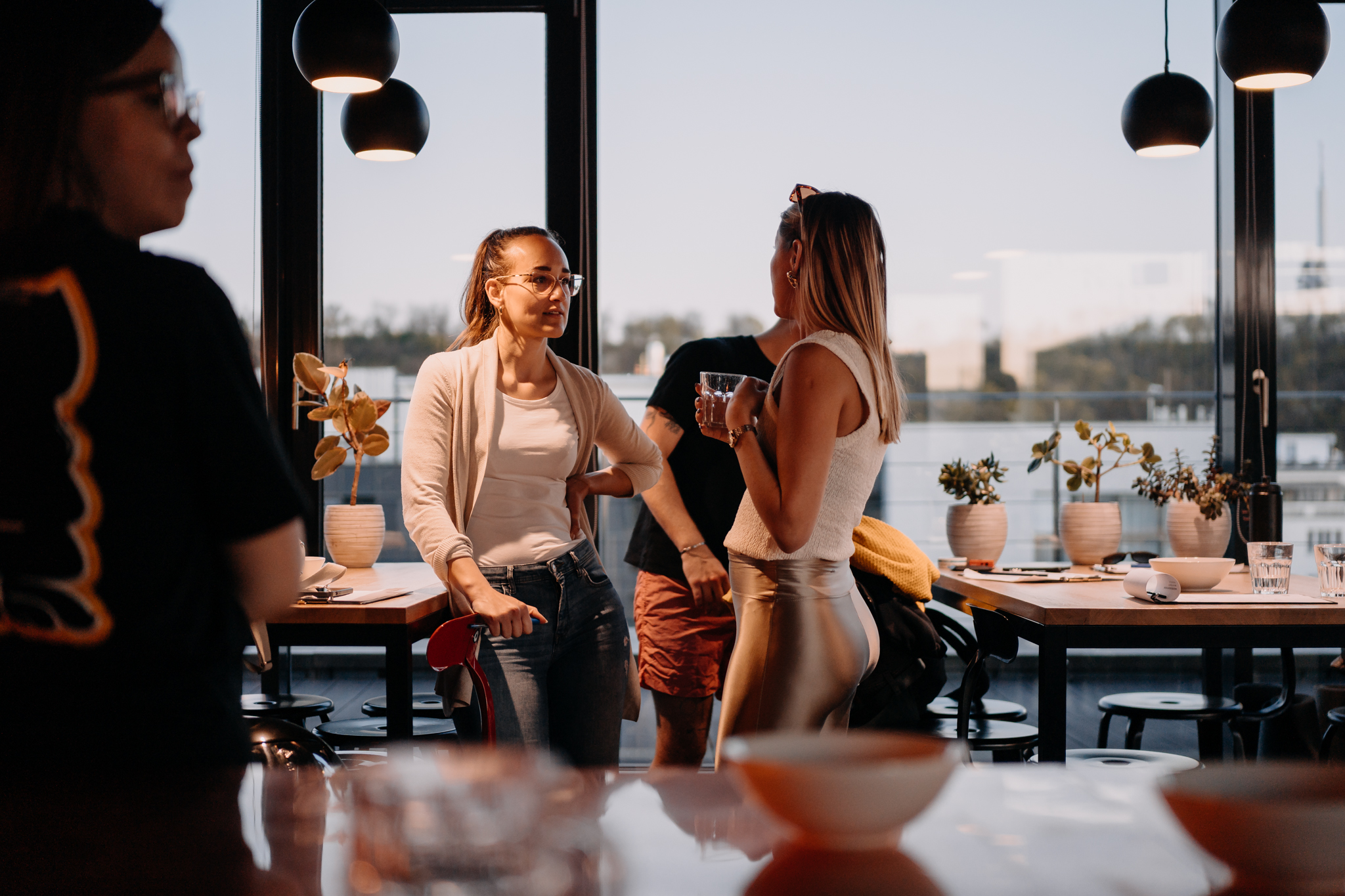 Guests laughing together in golden light at a Naked Minds evening