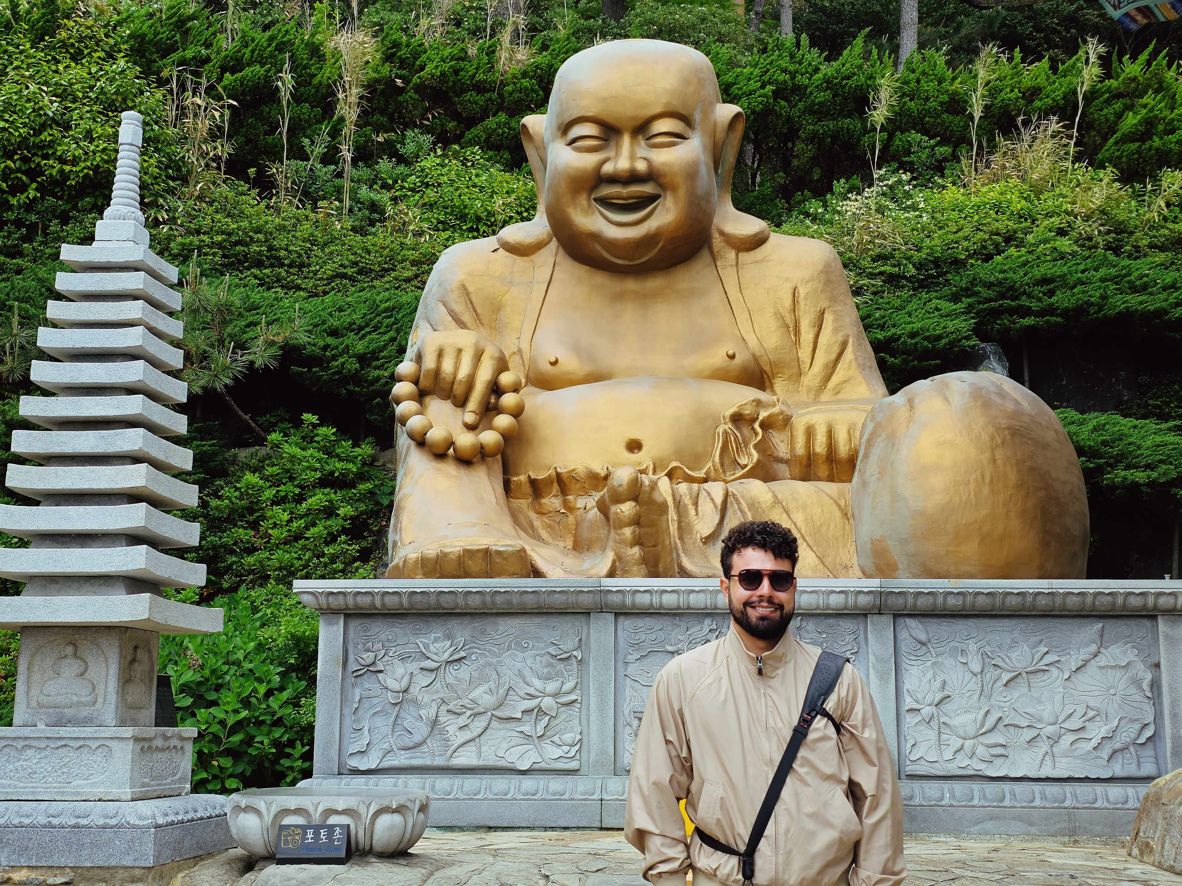 Standing in front of a giant golden laughing Buddha statue in Korea