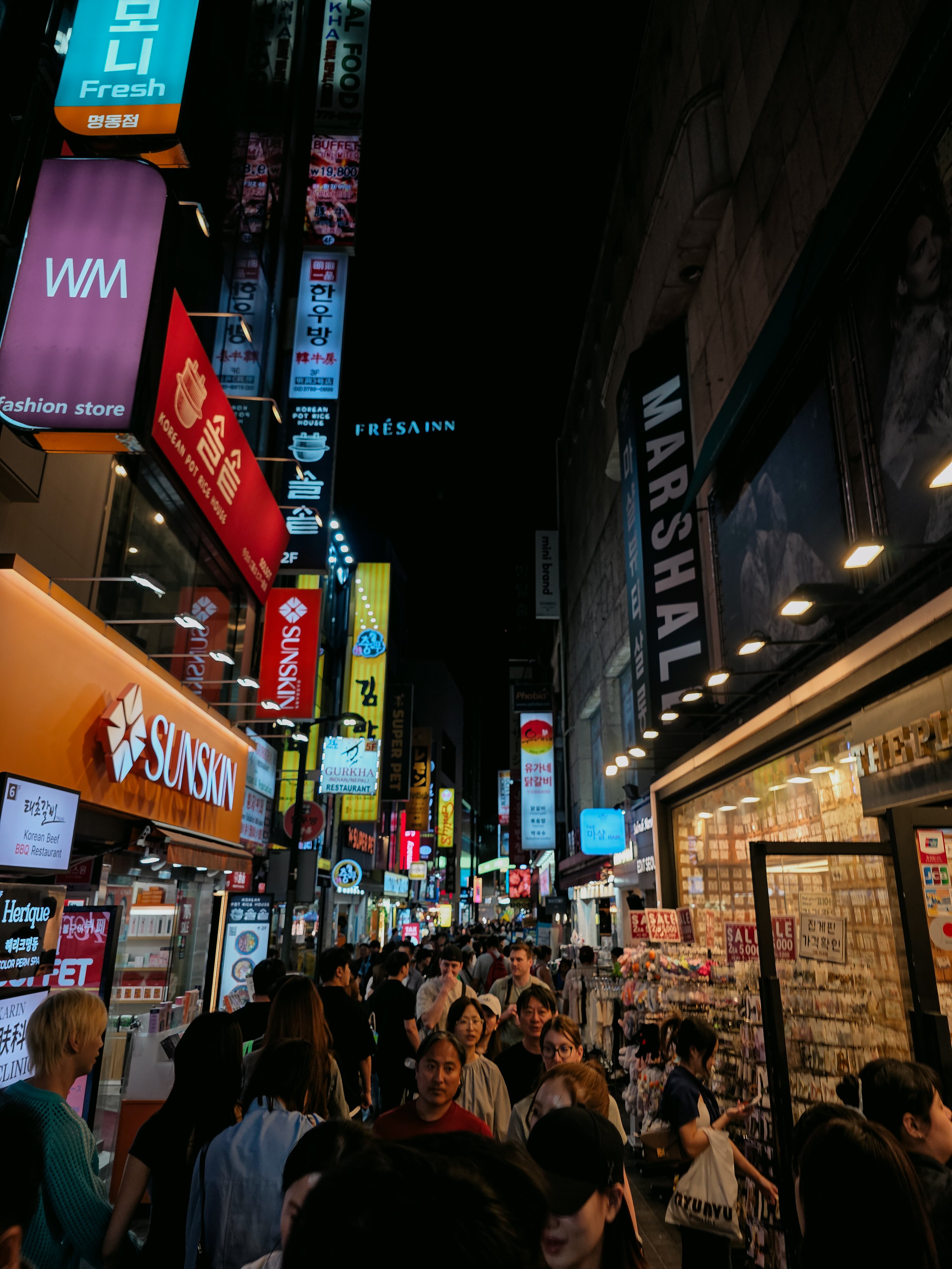 Crowded Myeongdong shopping street in Seoul at night