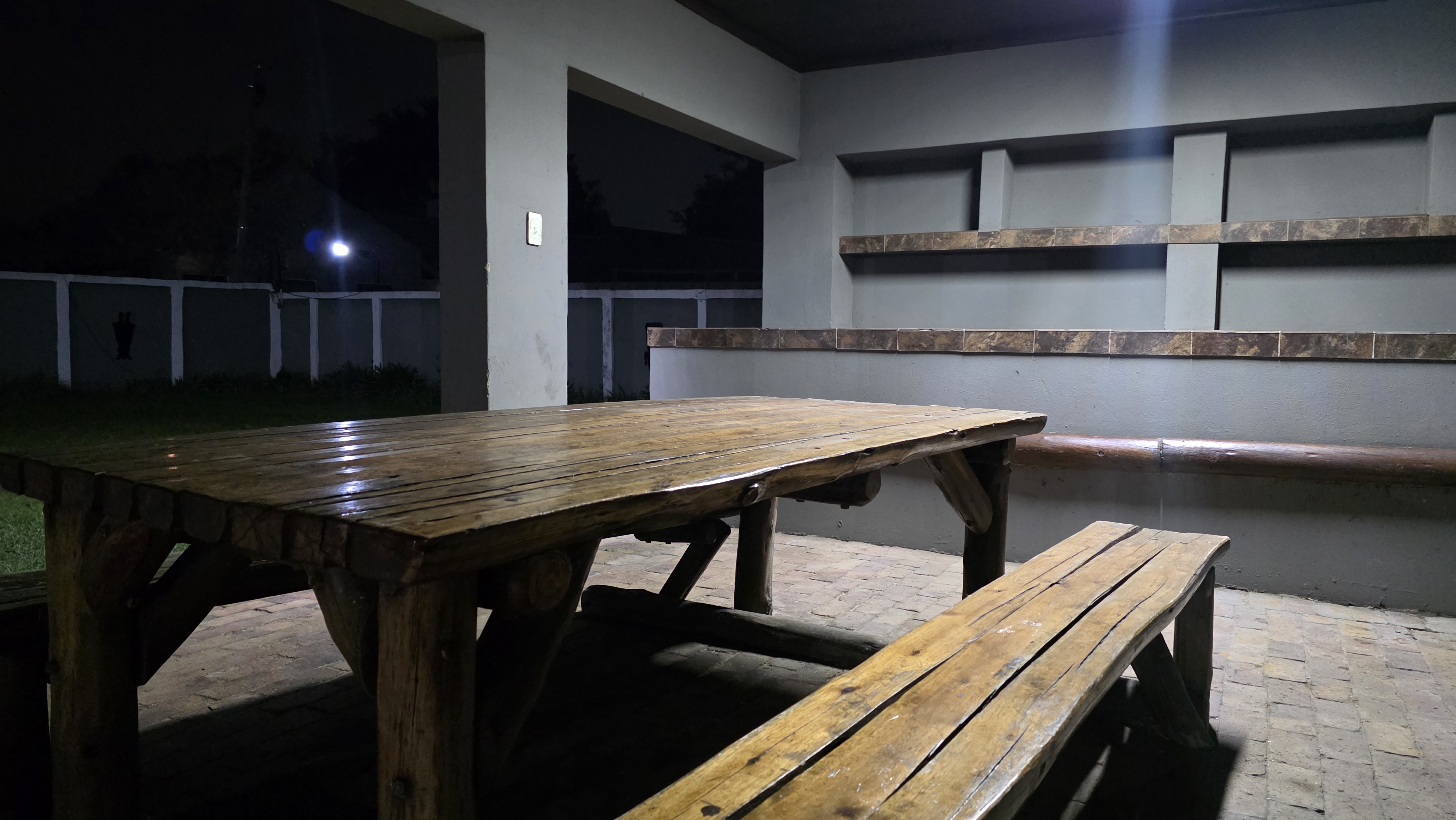 Braai area with wooden picnic table at night