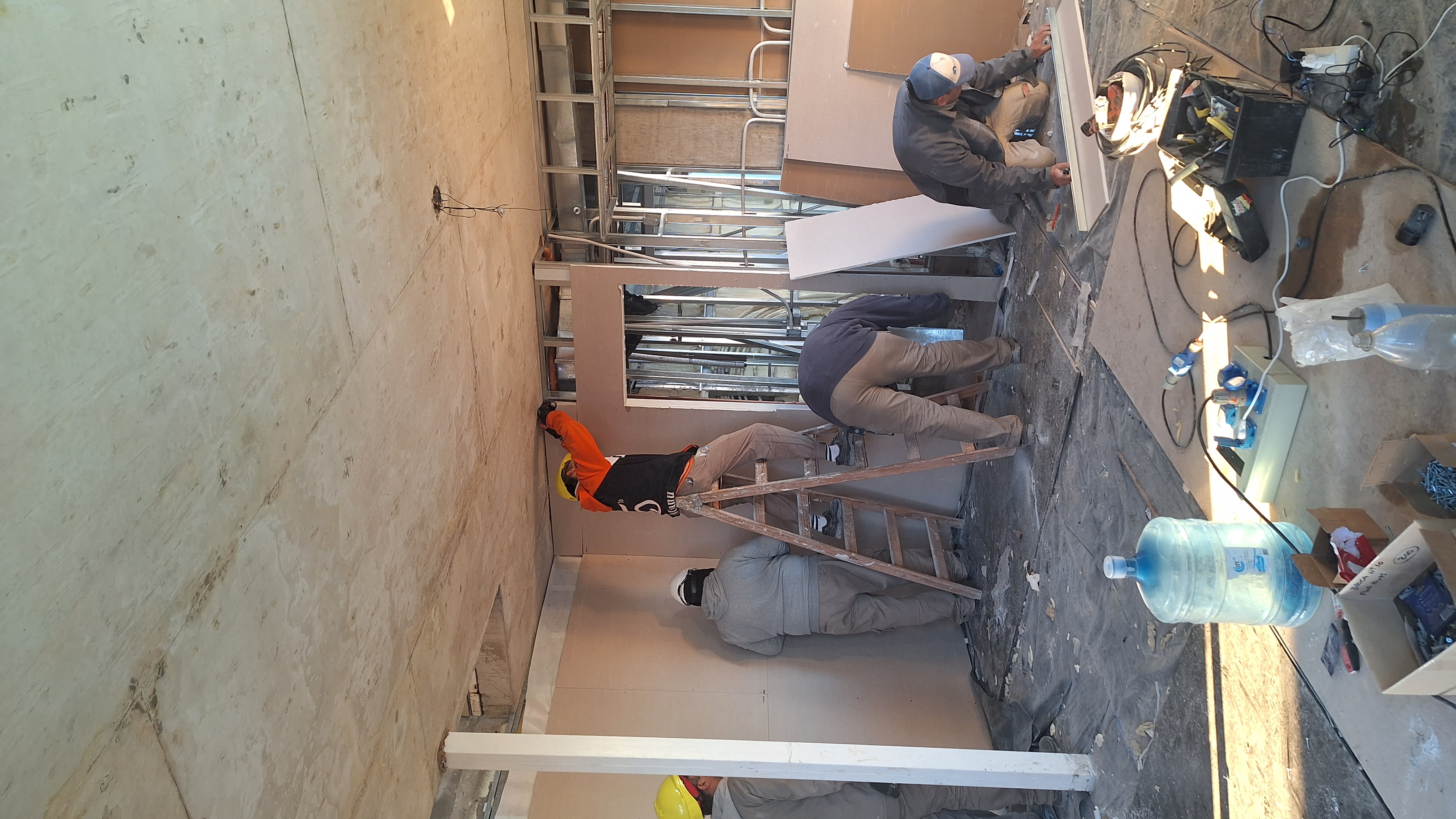 Operarios trabajando en tabiques de construcción en seco