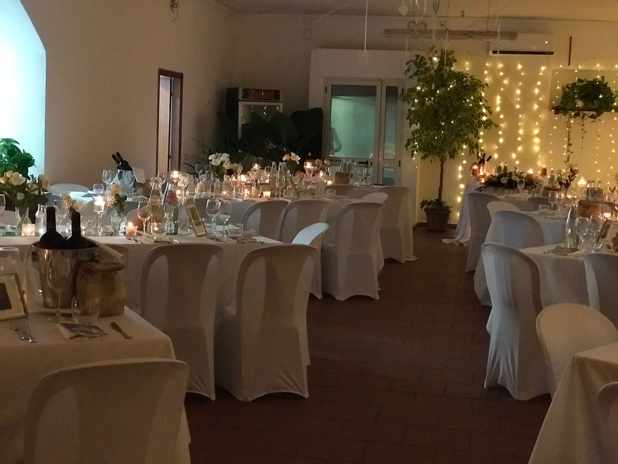 Salone interno con luci a catena e tavoli eleganti