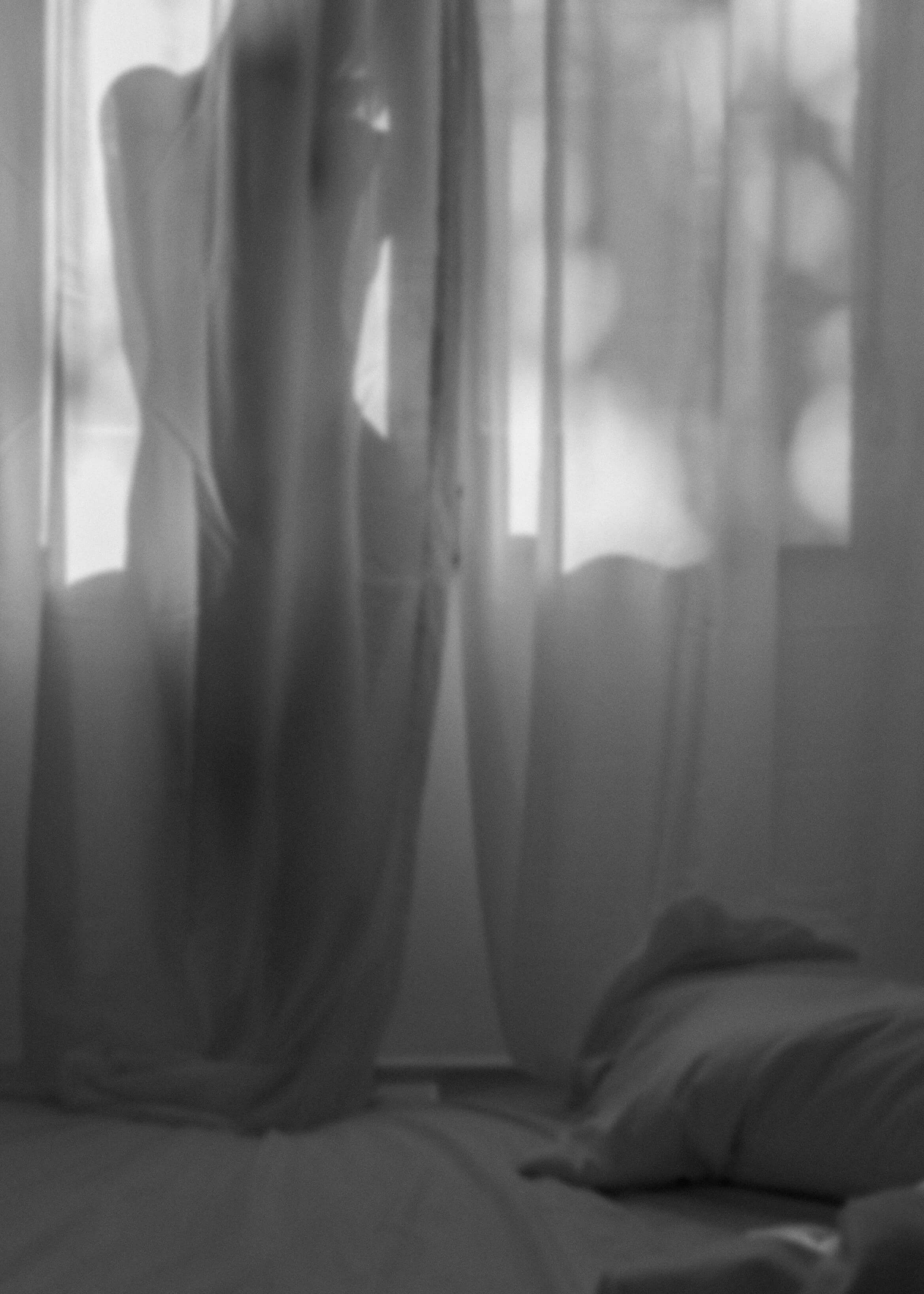 Blurred black and white image of curtains or fabric, creating an abstract effect