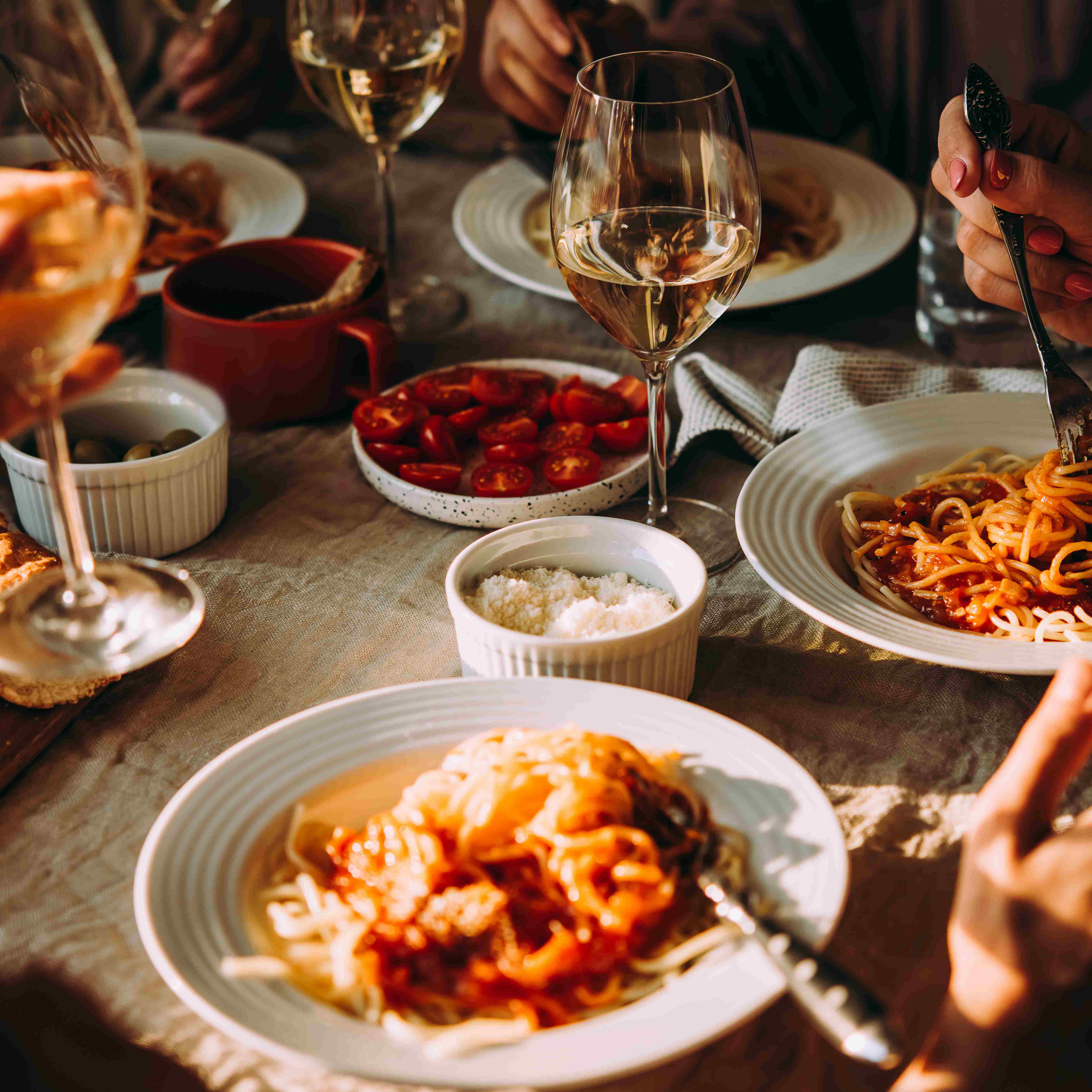 Italian dinner table with pasta dishes and wine glasses