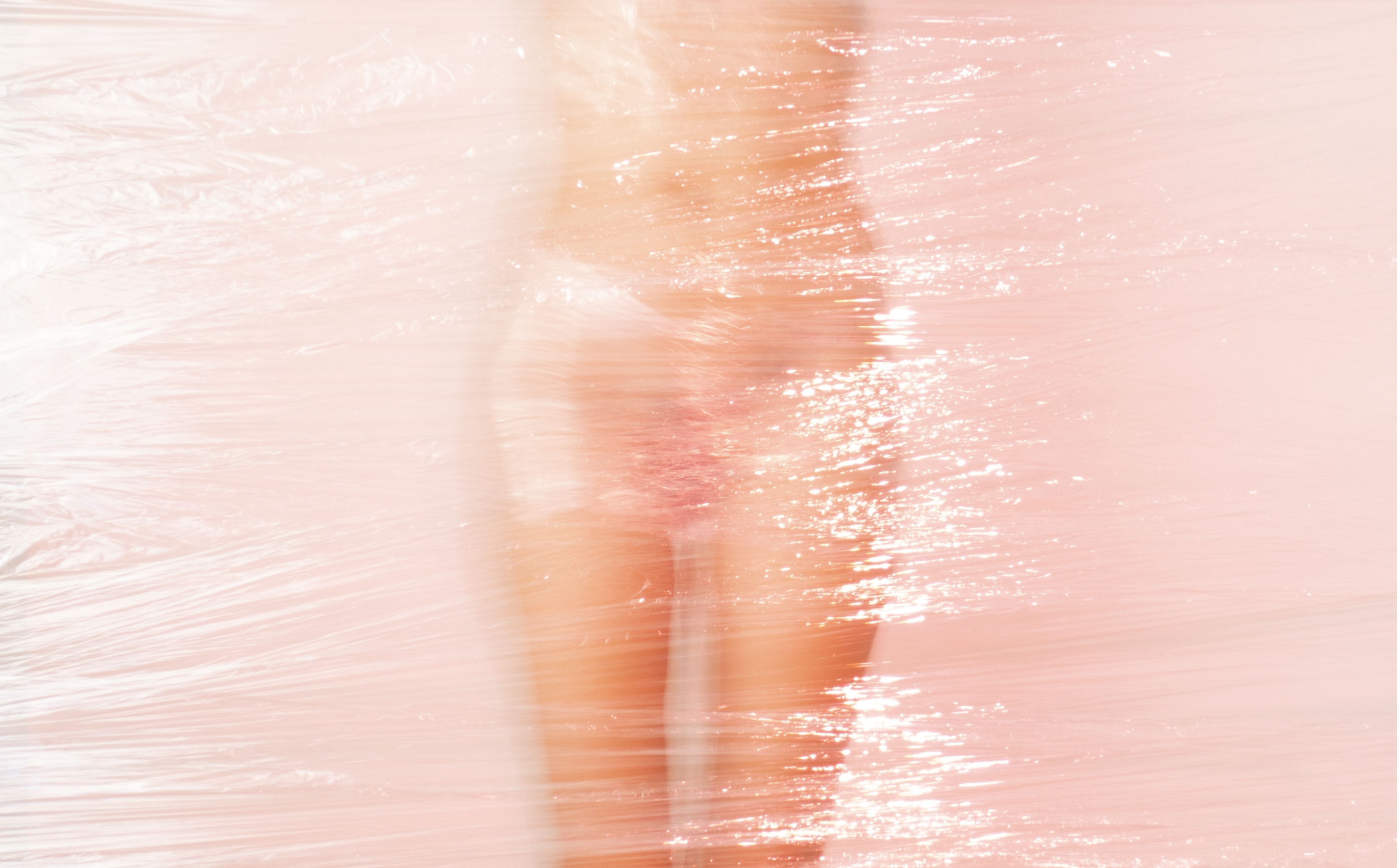 Abstract image with pinkish hue showing light reflections on a surface