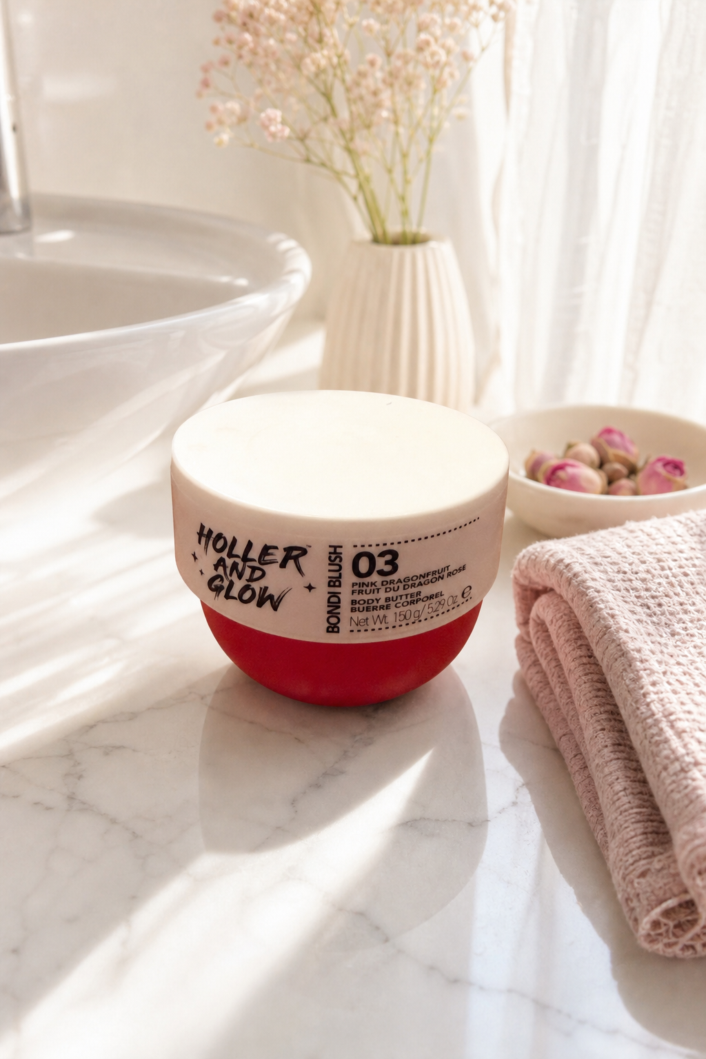Holler and Glow body butter product in bathroom setting with marble countertop