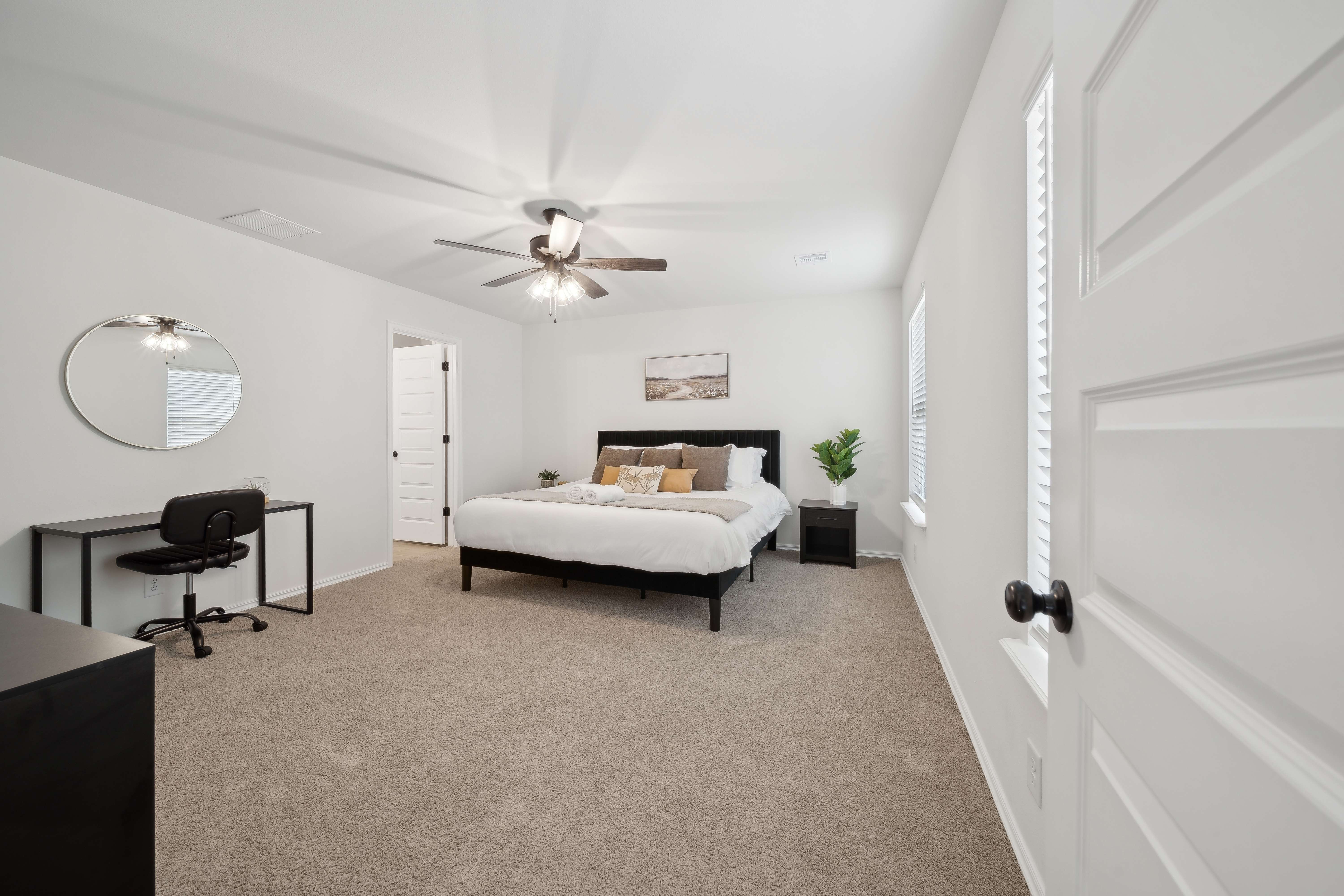 Spacious master bedroom with king bed and desk