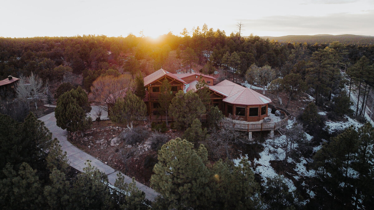 Aerial view at sunset of the timber lodge venue among snow-dusted pines in Show Low, Arizona