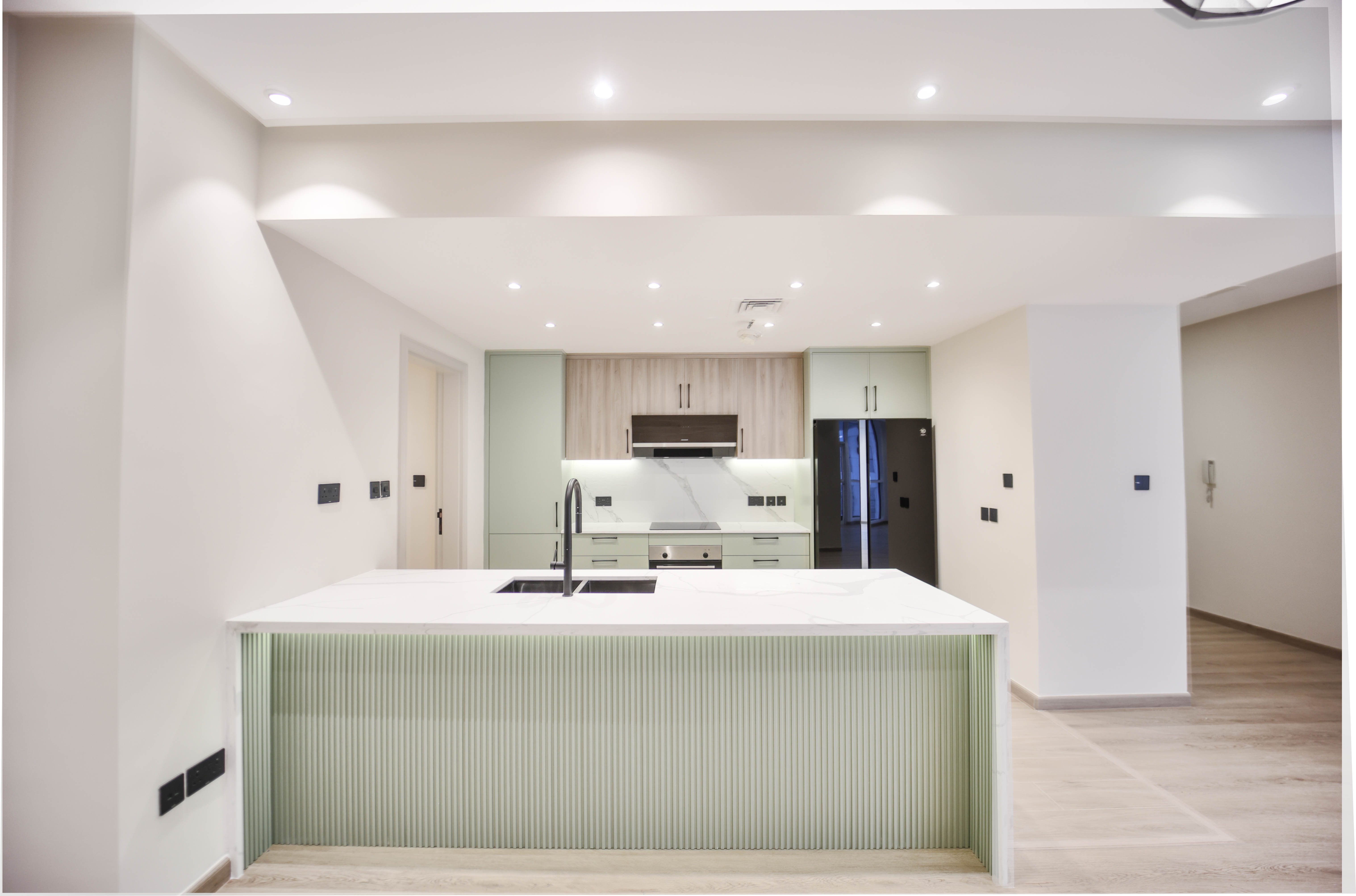 Modern kitchen with mint green ribbed island and sage cabinetry