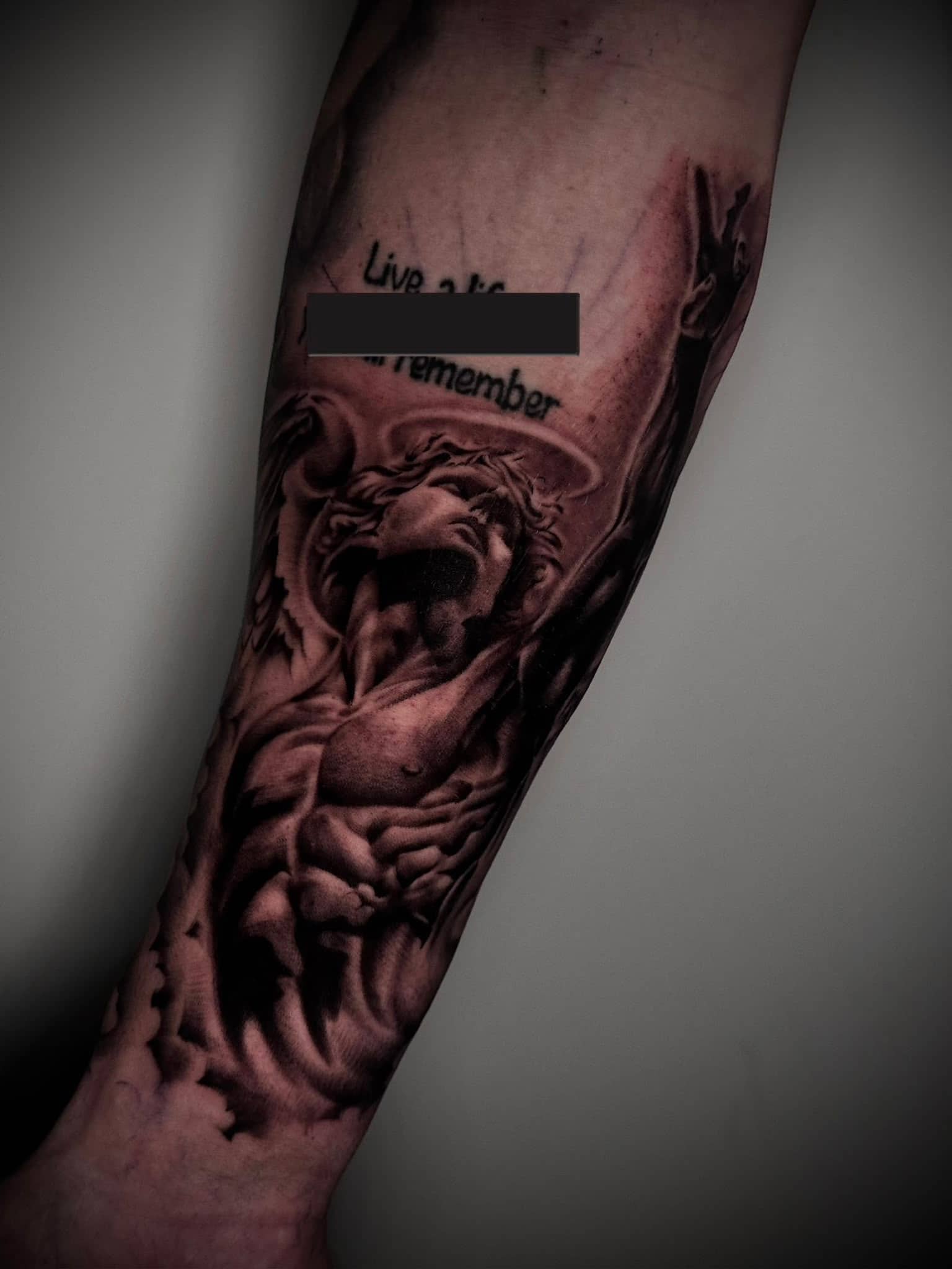 Black and Grey Engel-Statue Live a life to remember am Unterarm