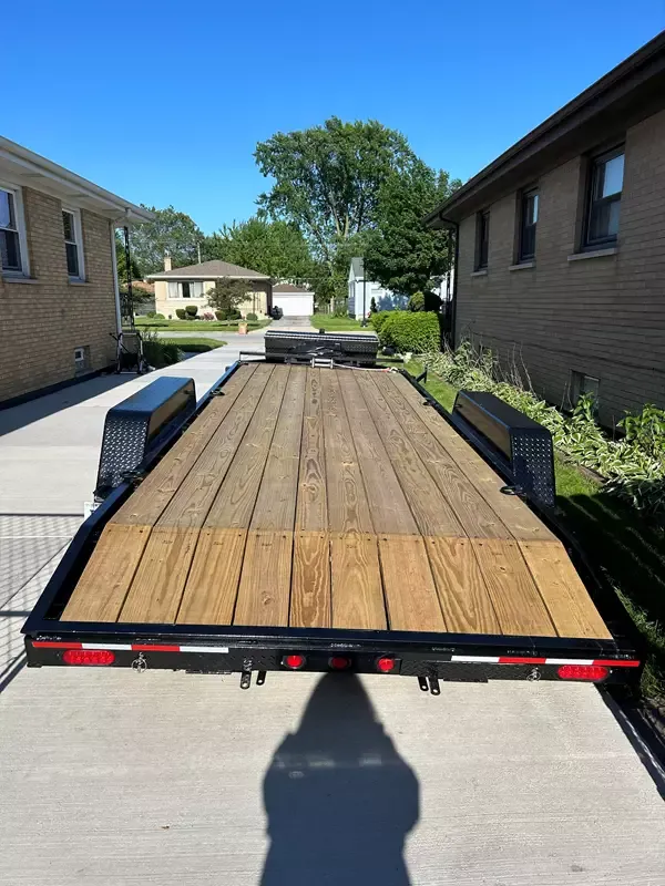 Red pickup truck on flatbed car hauler trailer being transported