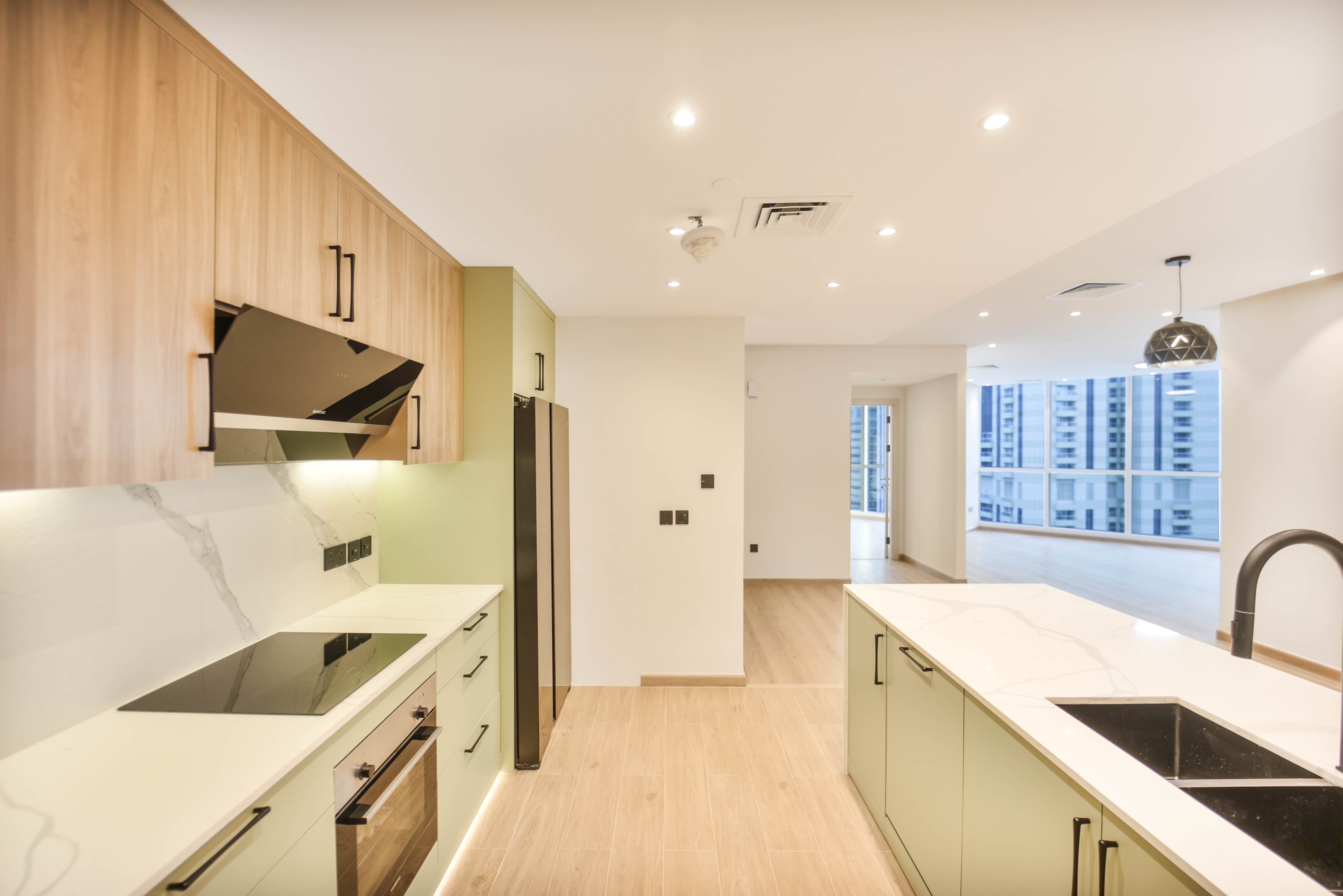 Modern kitchen with sage green and wood cabinetry