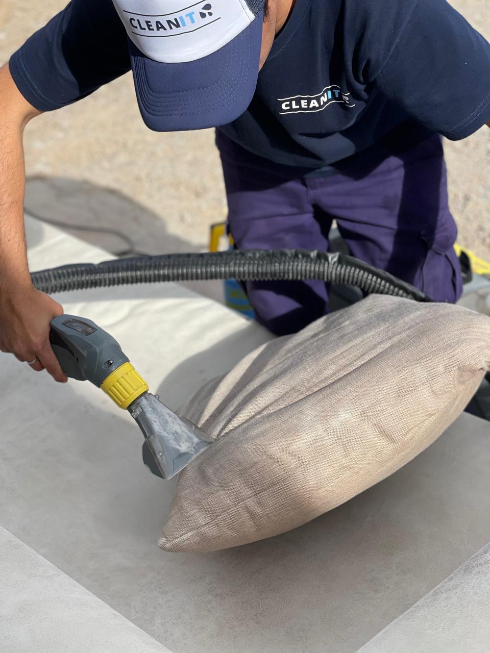 Profesional de Clean It limpiando tapizado de sillon